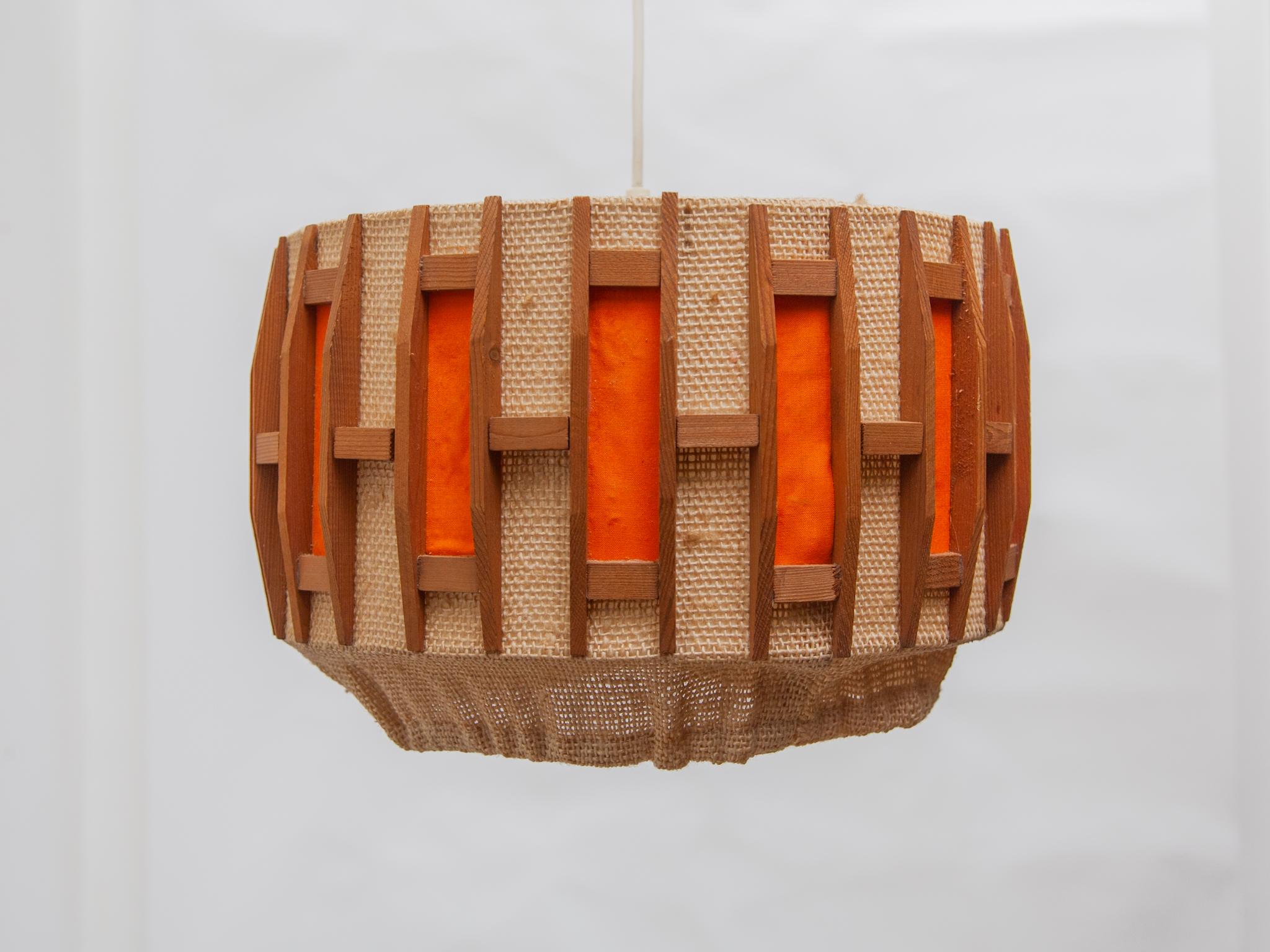 Lampe suspendue vintage des années 60. L'abat-jour rond est en teck et jute avec des accents orange, conçu par Massive, Belgique années 1960. Une belle lumière et un accent de lumière atmosphérique dans votre intérieur.
