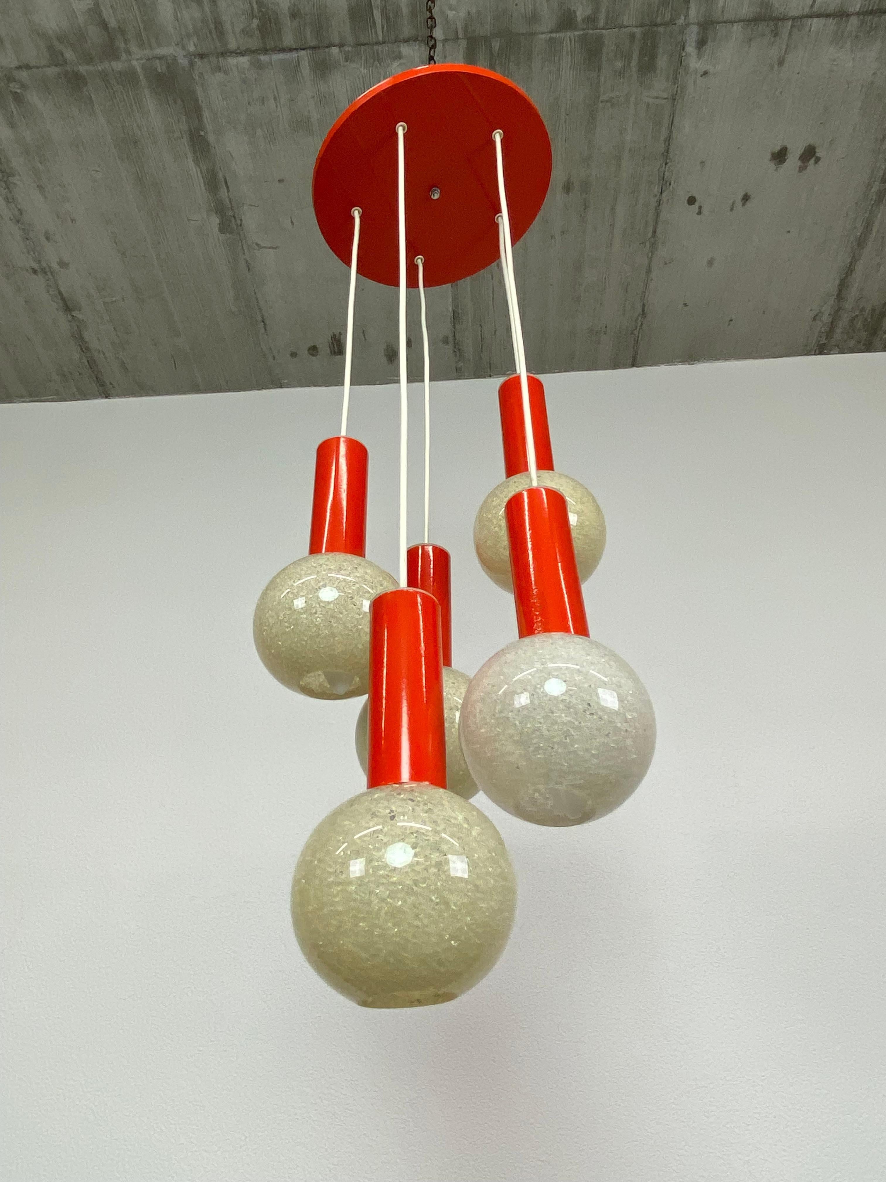 Orange midcentury modern hanging lamp with plastic lampshades.