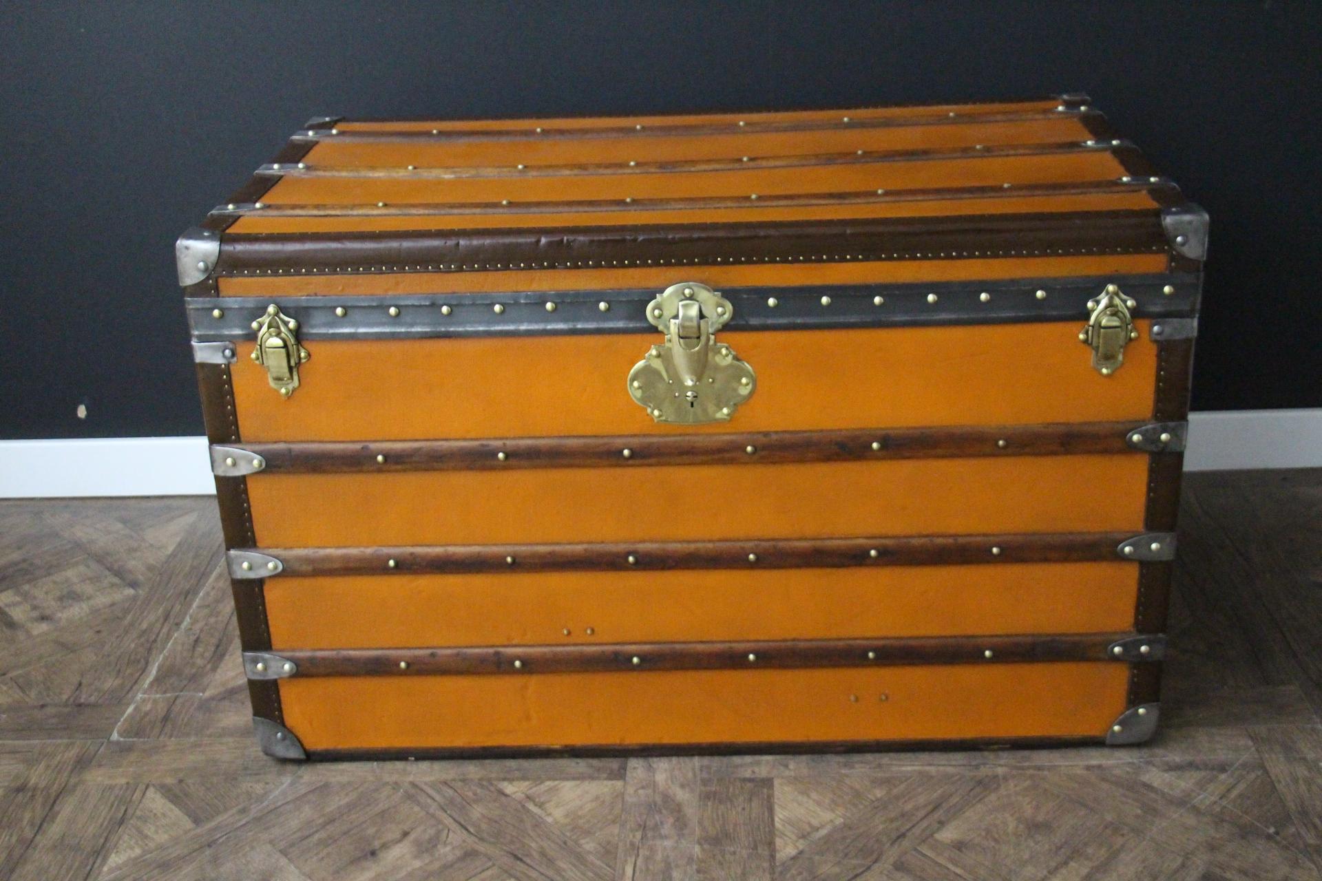 This beautiful and very rare Moynat trunk features beautiful orange canvas, chocolate color leather trim, large leather side handles with stamped Moynat flanges , Moynat plaques on both sides and solid brass lock. Its patina is magnificent. Moreover