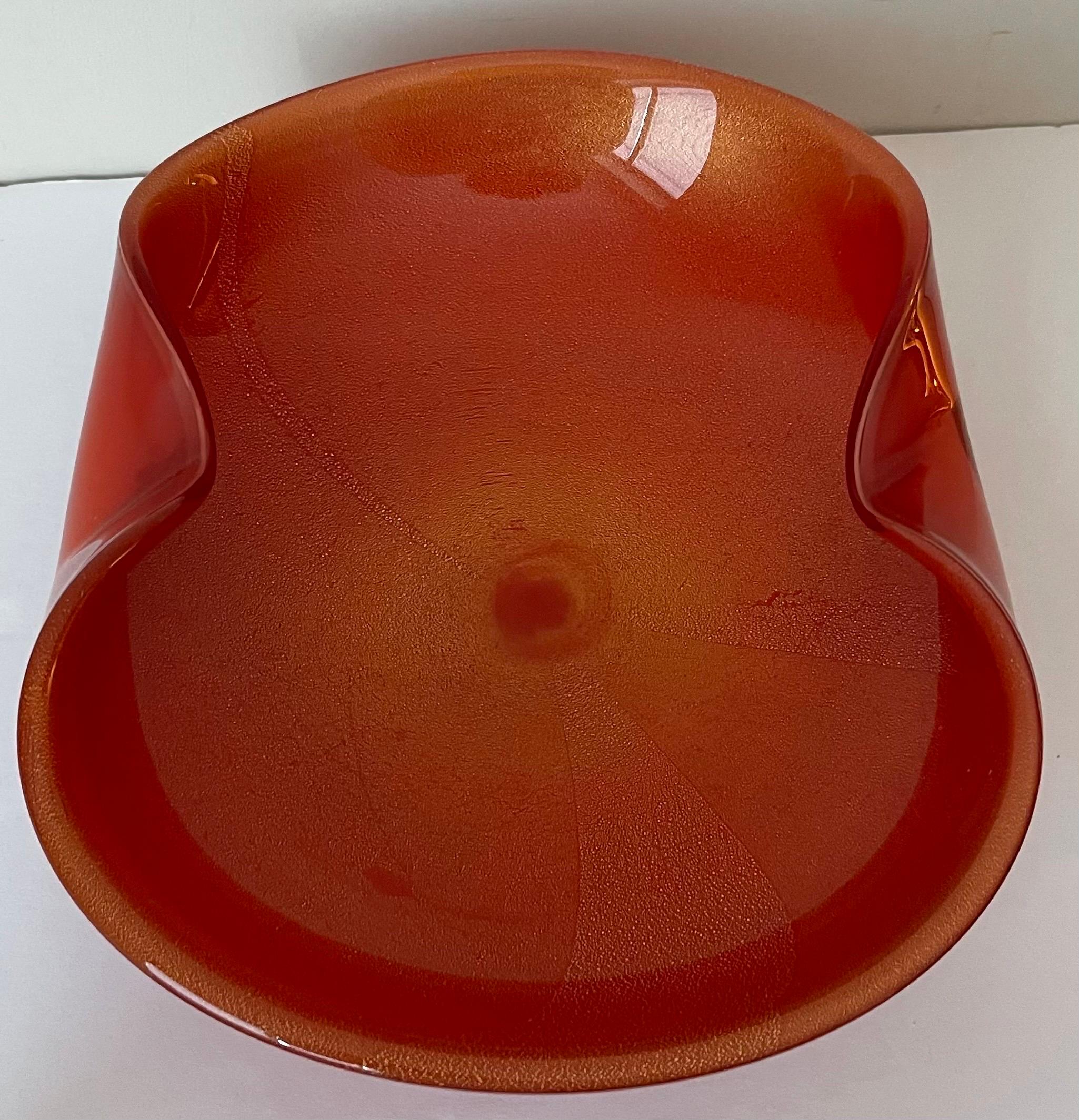 Large mid-century Murano glass ashtray by Barbini. Orange glass with all-over gold flecks and lightly swirled center design.