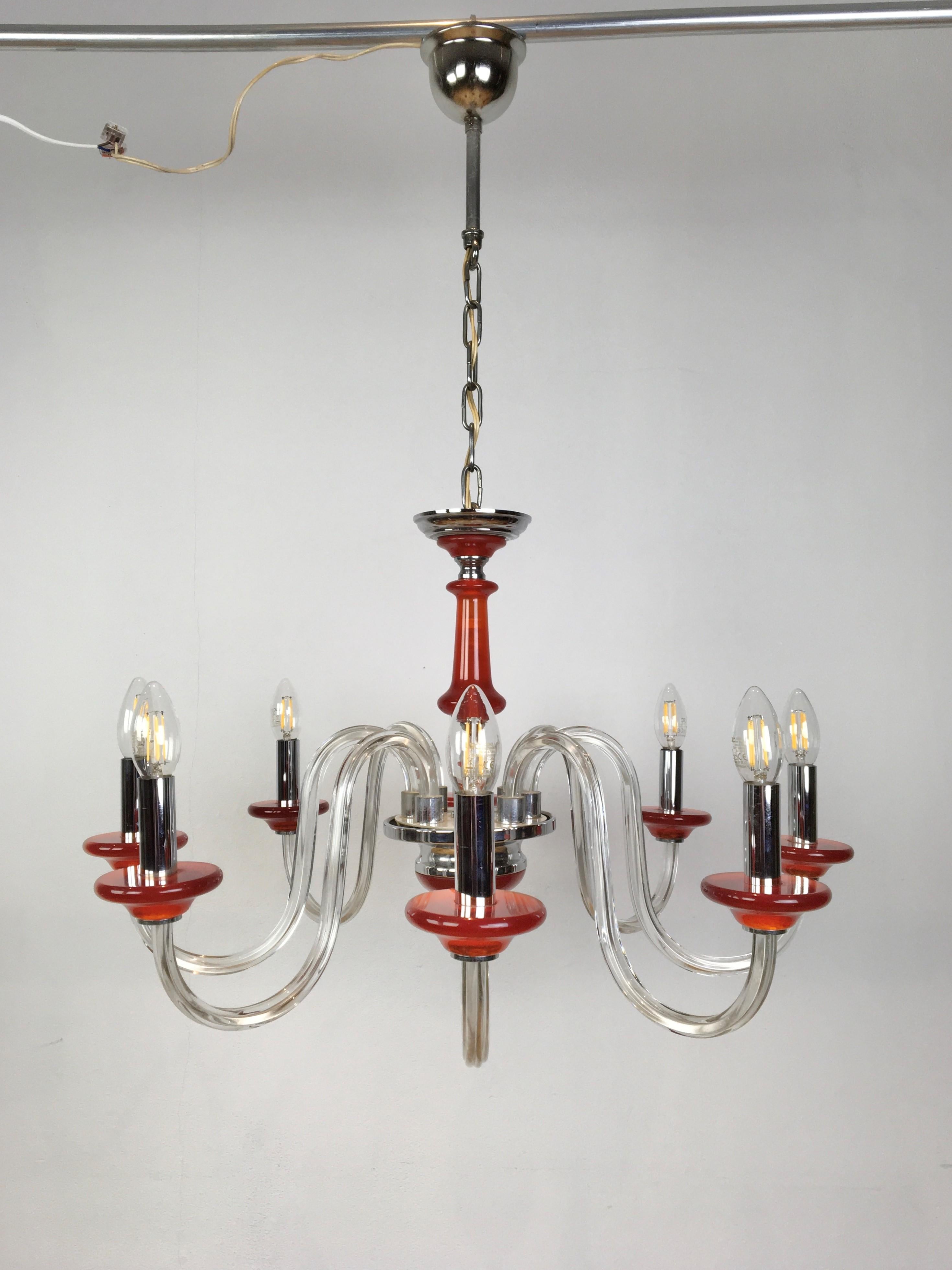 8-armed Murano glass chandelier. 
This mid-20th century orange ceiling light has 8 curling arms.
A vintage Italian chandelier with orange murano glass details.

Dimension of height is without chain and hang up system.

Do note that we have the same
