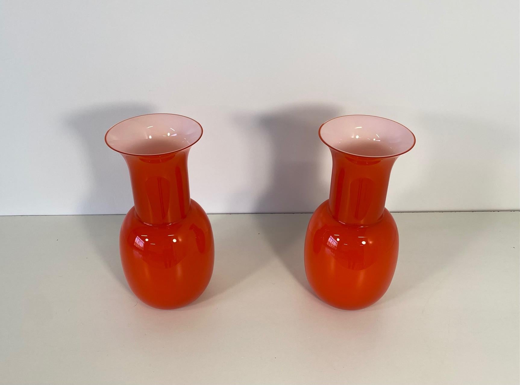 This pair of vases was produced in Italy, more precisely in Murano, which is the world's capital of glass art making and crafting. 
They are completely made of an unique piece of Murano glass, worked with a particular technique so that the inside