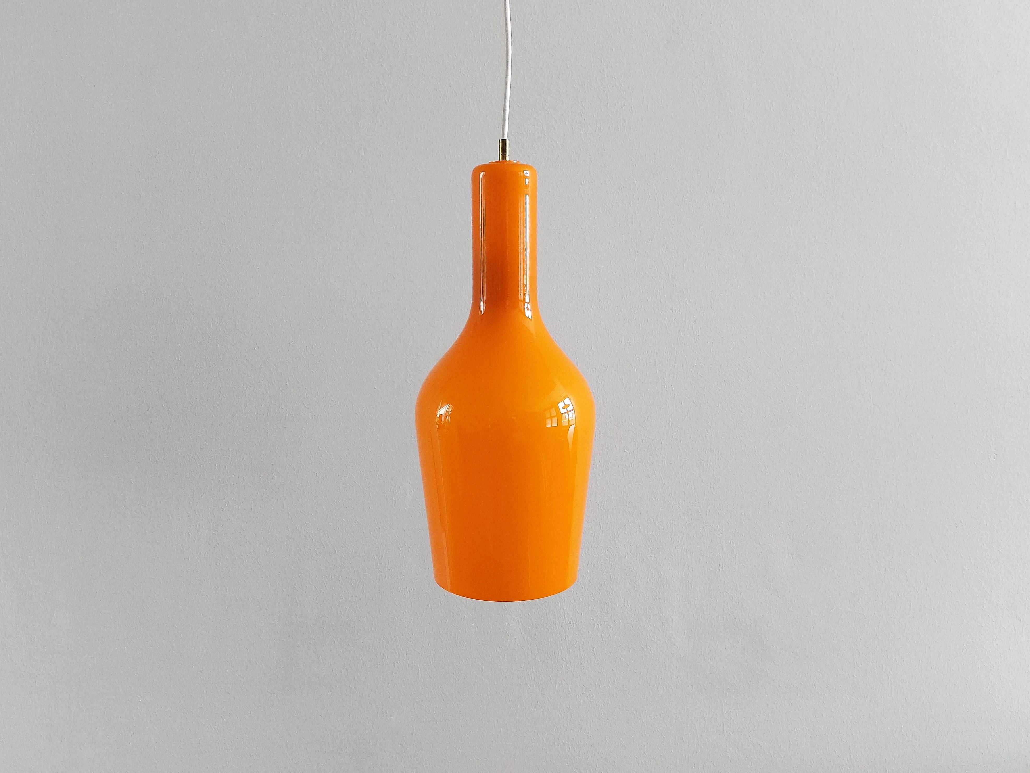 This orange glass pendant lamp was designed by Gino Vistosi for Vistosi in Italy in the 1960's. It has a bright orange glass outside with a white opaline inside that gives a beautiful warm light. This lamp is in a very good to excellent condition.
