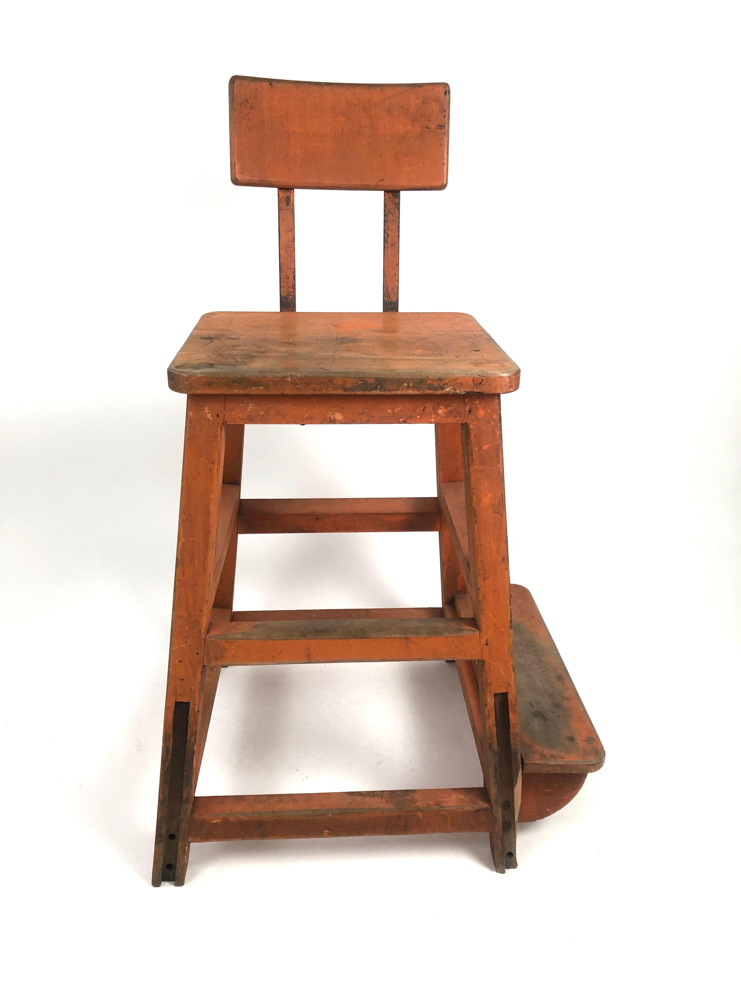 A sculptural, very sturdy and functional industrial orange painted wood and metal stool, or high chair, from a factory, circa 1920s, the curved rectangular back attached to the seat with iron bands connected to the square seat supported by 4