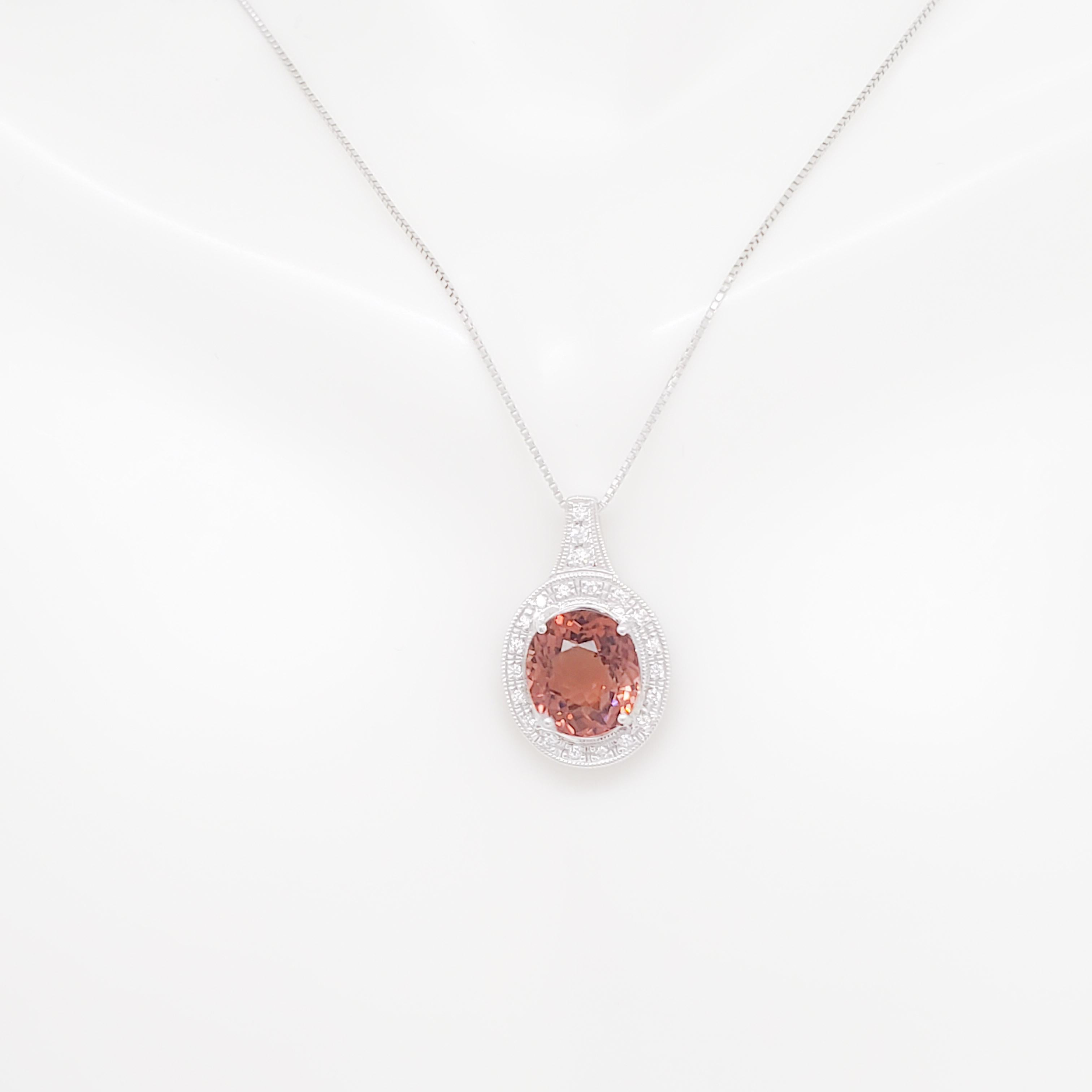 Gorgeous 6.00 ct. orange pink tourmaline oval with 0.21 ct. good quality white diamond rounds.  Handmade in platinum.  Chain is 18