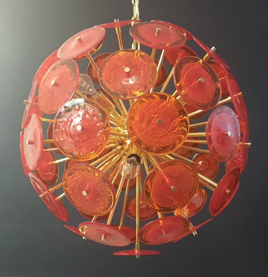 Italian round sputnik chandelier with red orange Murano glass discs hand blown with bubbles using Pulegoso technique, mounted on 24k gold plated metal frame by Fabio Ltd / Made in Italy
Measures: diameter 23.5 inches, height 23.5 inches plus chain
