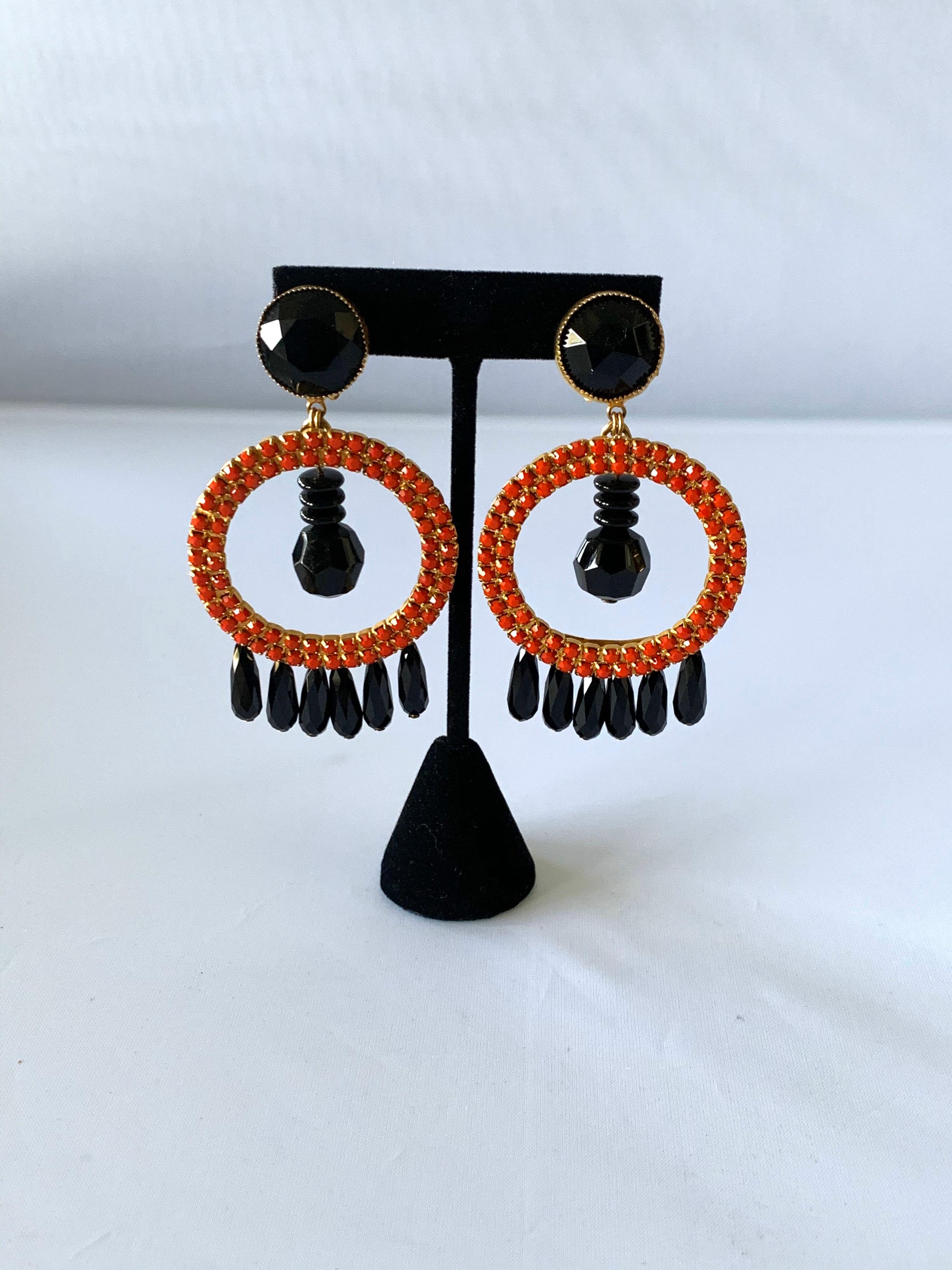 Contemporary chic orange-red black jet vintage statement clip-on earrings, comprised out of gold-tone metal which is adorned by rhinestones and dangling faceted jet beads. Designed by William de Lillo for W. de Lillo, Ltd New York, circa 1969/70.