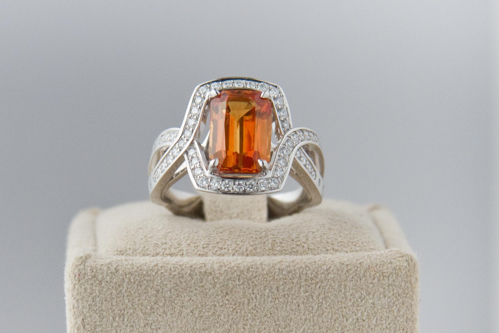Coktail ring with natural orange sapphire, emerald cut ornamented with 58 diamonds color F.  White gold 18 ct 
Weight of sapphire  : 3.84 ct 
Size of sapphire : 10 x 7mm. 
US Size : 6 
GIA certificate attached. 
The design and conception of the ring