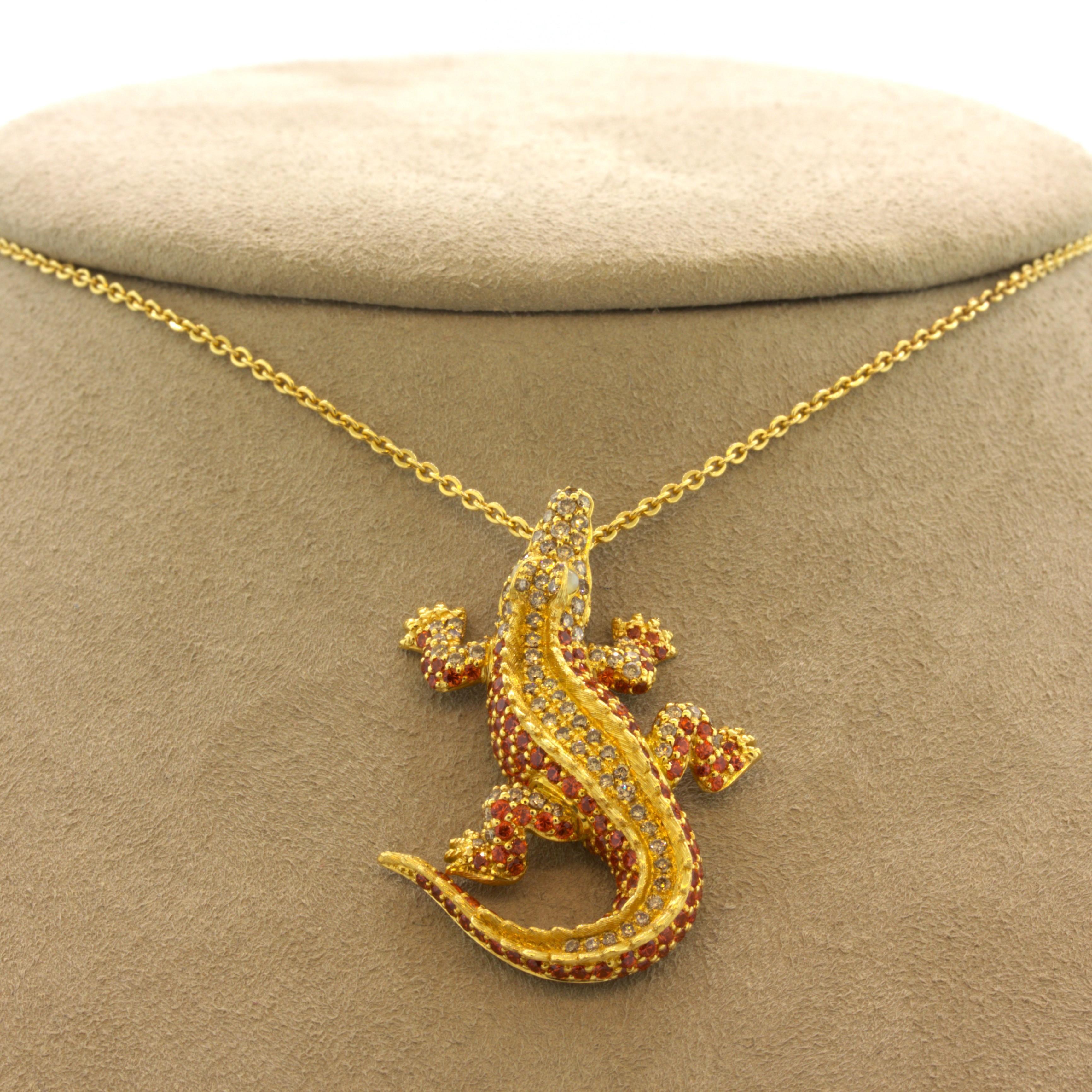 A fierce yet cut alligator studded with gems and diamonds! It features 1.78 carats of bright and vibrant orange sapphires along with 0.39 carats of round brilliant-cut diamonds set around the alligator’s body. Adding to that, the two cats' eye