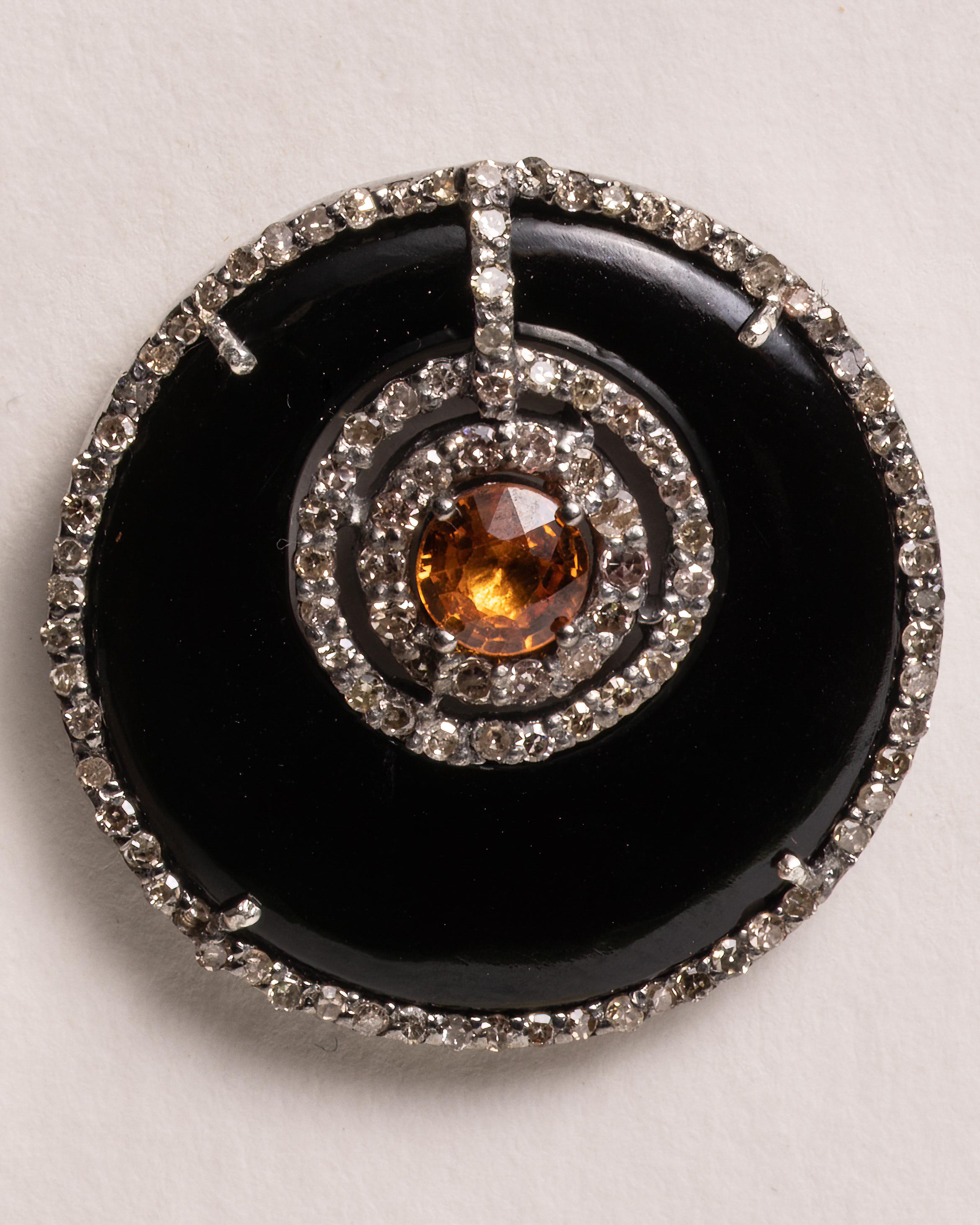 A pair of round stud earrings of black onyx with a round, faceted orange sapphire and both bordered with pave`-set round, brilliant cut diamonds.   Set in sterling silver with an 18K gold post for pierced ears.  Diamonds total 1.3 carats, the black