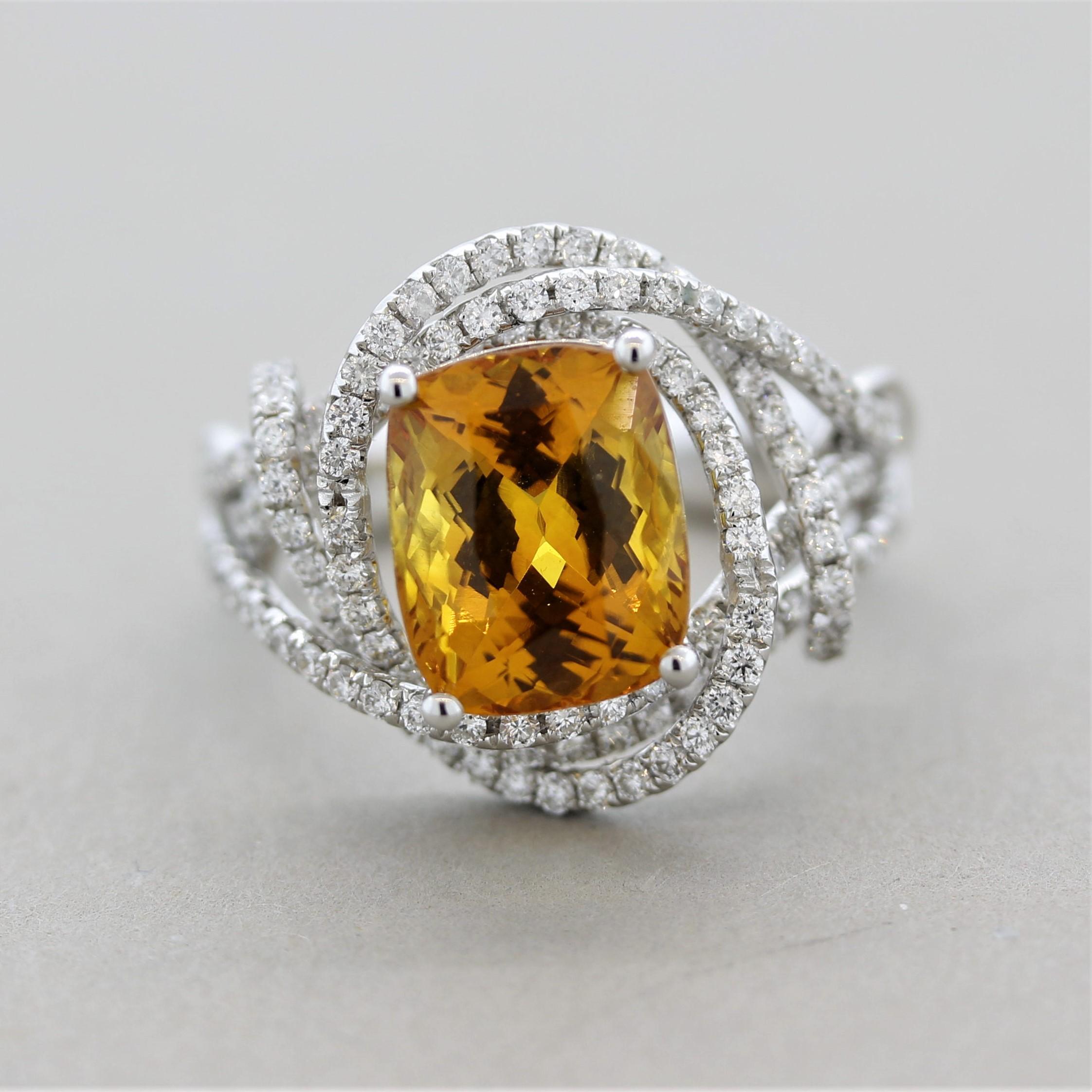 A brilliant ring featuring a GIA certified natural yellowish-orange sapphire! It weighs 4.84 carats and is free of any eye-visible inclusions allowing the stones natural brilliance and bright color to shine! It is shaped as a cushion and is accented