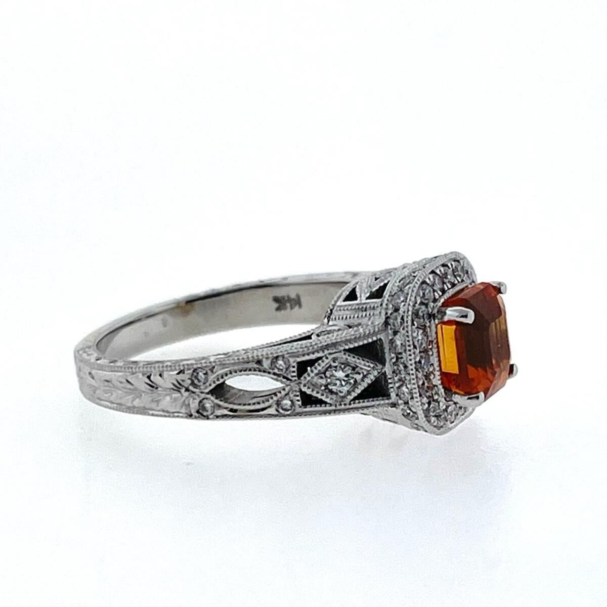 This 14K White Gold Diamond Ring has one 1.55ct Square Emerald Orange Sapphire Center with Twenty-Nine (29) Round Brilliant Cut Diamonds weighing 0.63ctw F/SI in Quality. The ring has milgrain edging and it is sized at a size 5.25 (can be resized). 