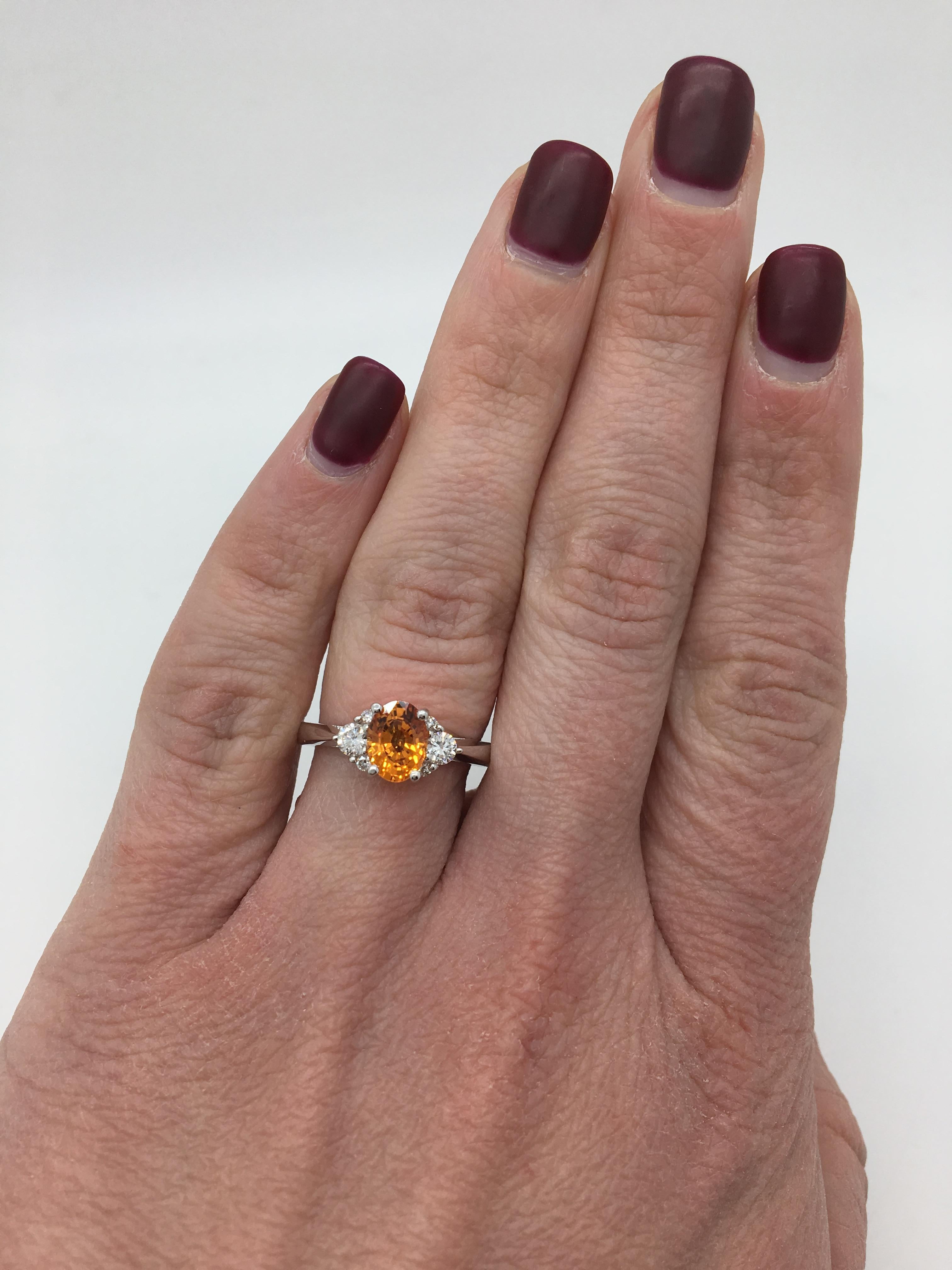 Beautiful Orange Sapphire and Diamond Ring set in 14K white gold.

Gemstone: Orange Sapphire & Diamonds
Gemstone Carat Weight: Oval Cut 1.09CT Orange Sapphire
Diamond Carat Weight: Approximately .25CTW 
Diamond Cut: 6 Round Brilliant
Color: Average
