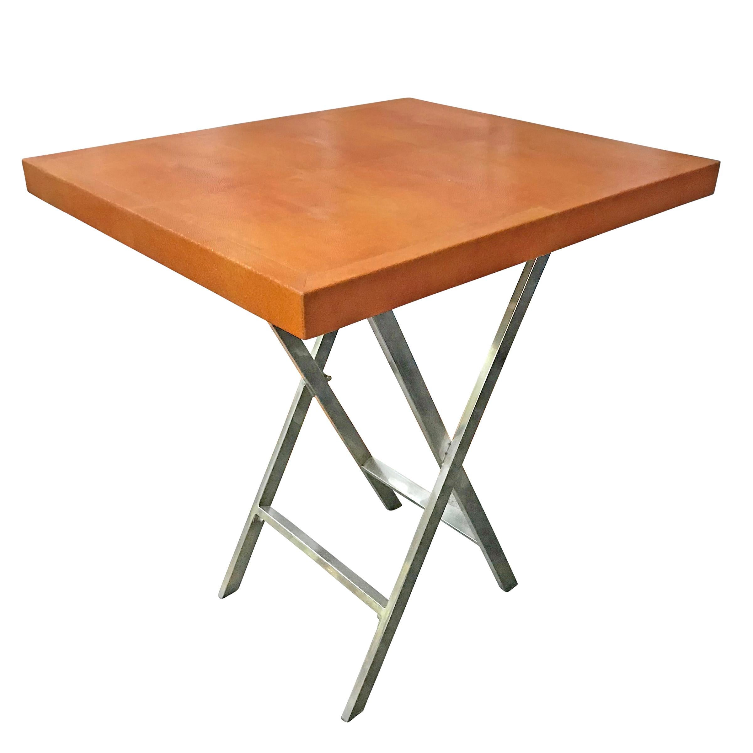 A late 20th century American side table with an orange shagreen top, chrome x-form legs. The table appears to fold, however, it is stationary.