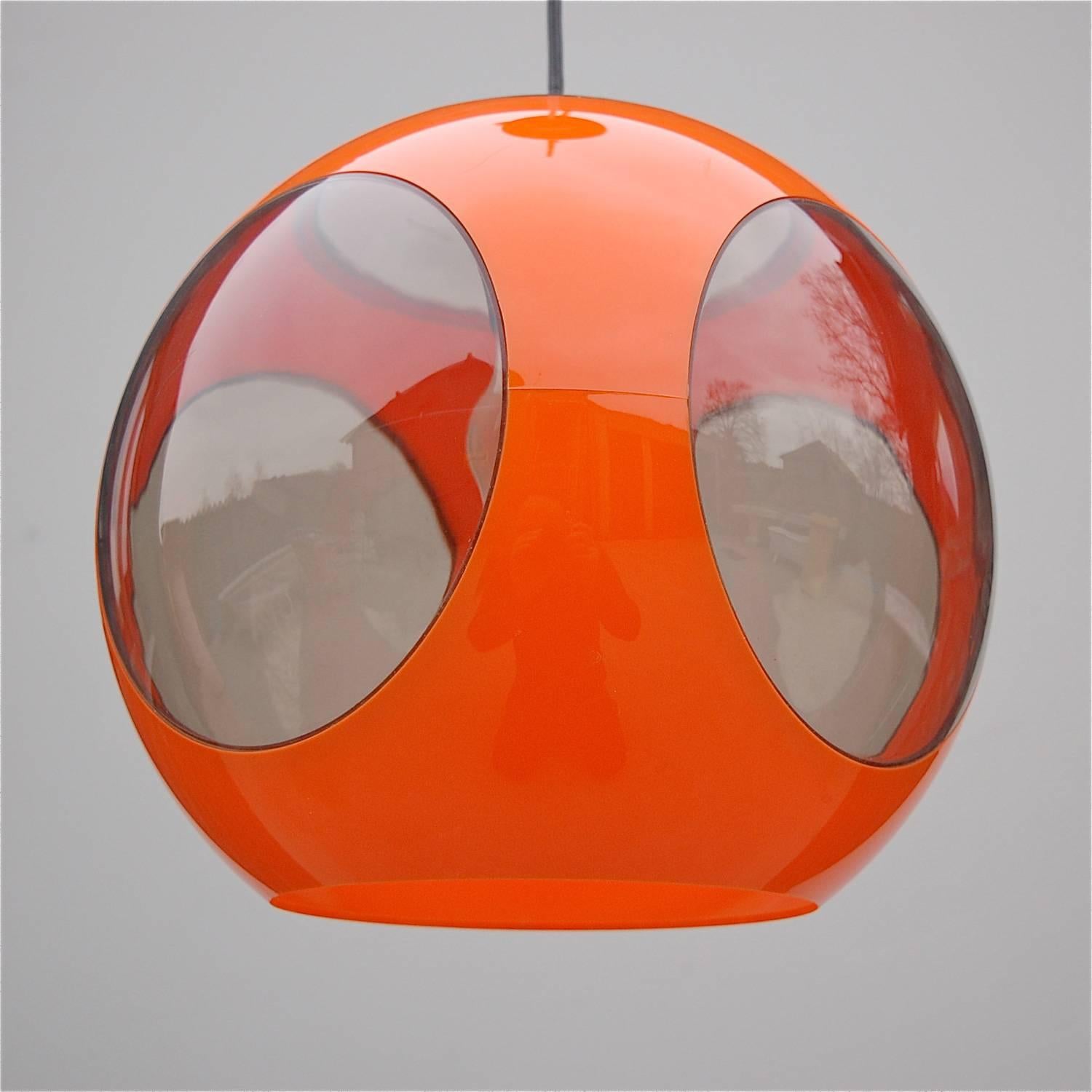 This UFO, space age lamp by designer Luigi Colani has an orange plastic circular body with smoked acrylic inserts and was produced in the 1970s. It is 30cm is diameter and hung from the ceiling it has a height of 55cm. In very good vintage