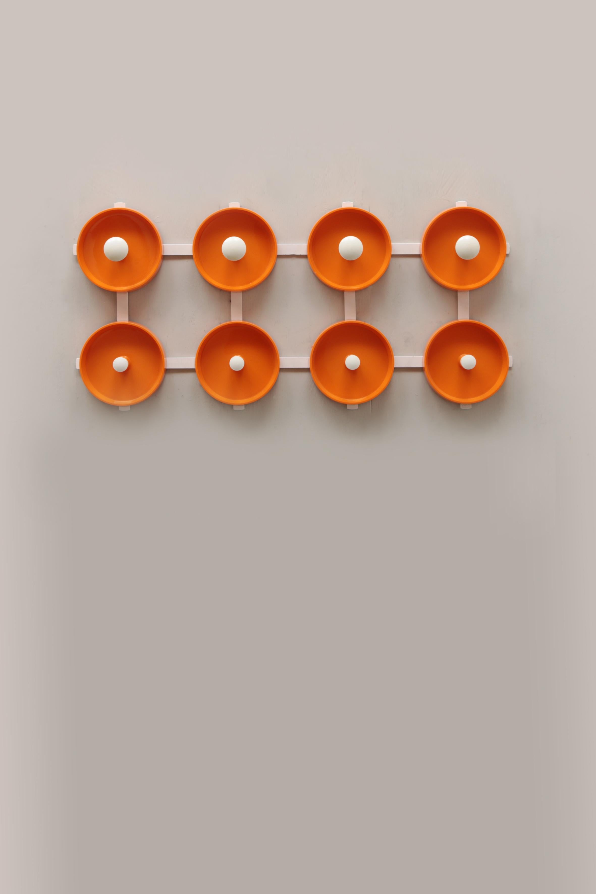 This is a very nice separate wall coat rack with white hooks.

The back is made of white metal with beautiful plastic orange round scales with a hook for your coat in the middle. The coat rack has 8 hooks to hang your coat on.

Sustainable: