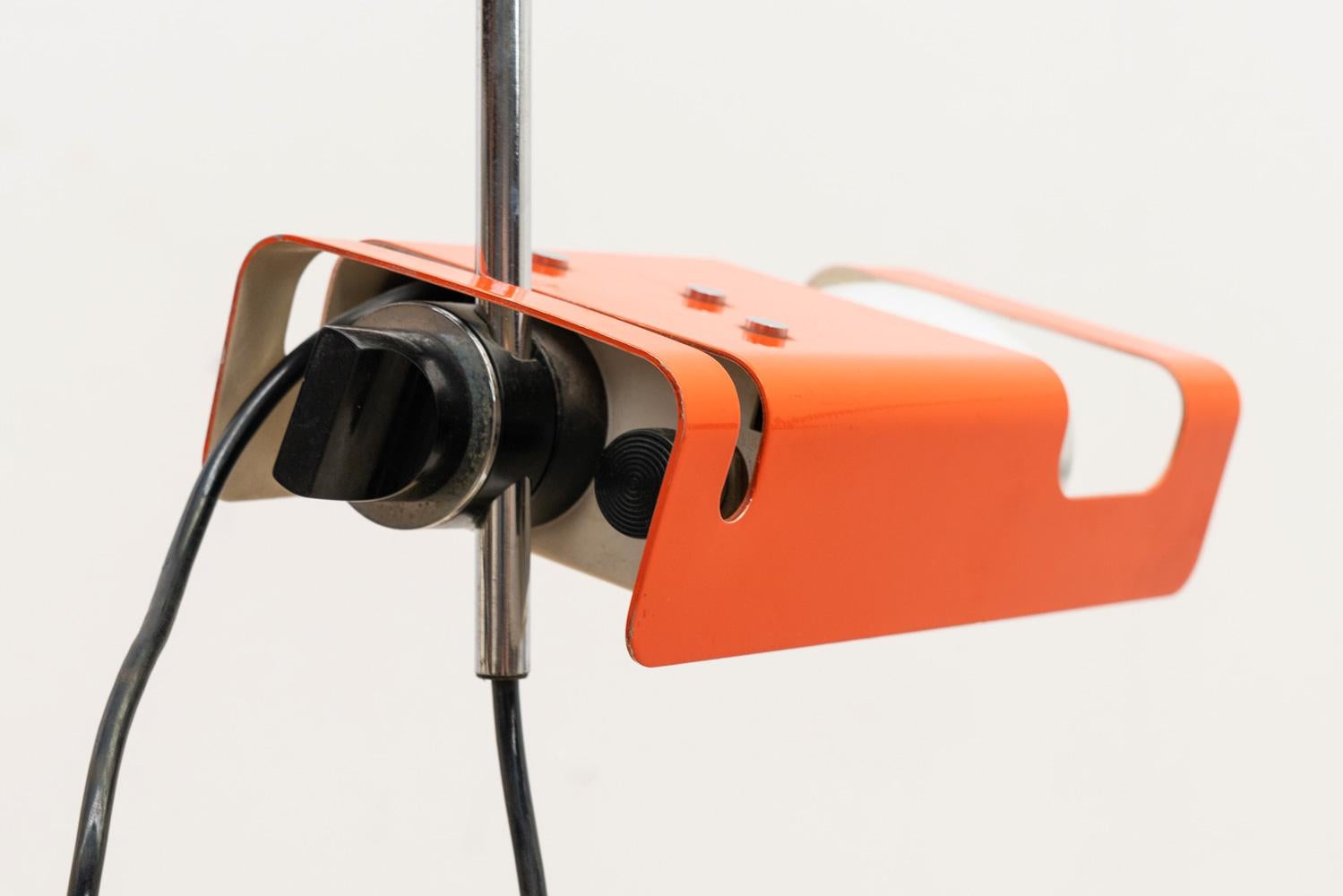 Joe Colombo  designed the Model 293, also known as the Spider, a table lamp characterized by its arched metal stem with an adjustable clamp. Manufactured by Oluce in Milan, Italy, in the 60s, it features a rectangular orange lacquer shade. This lamp