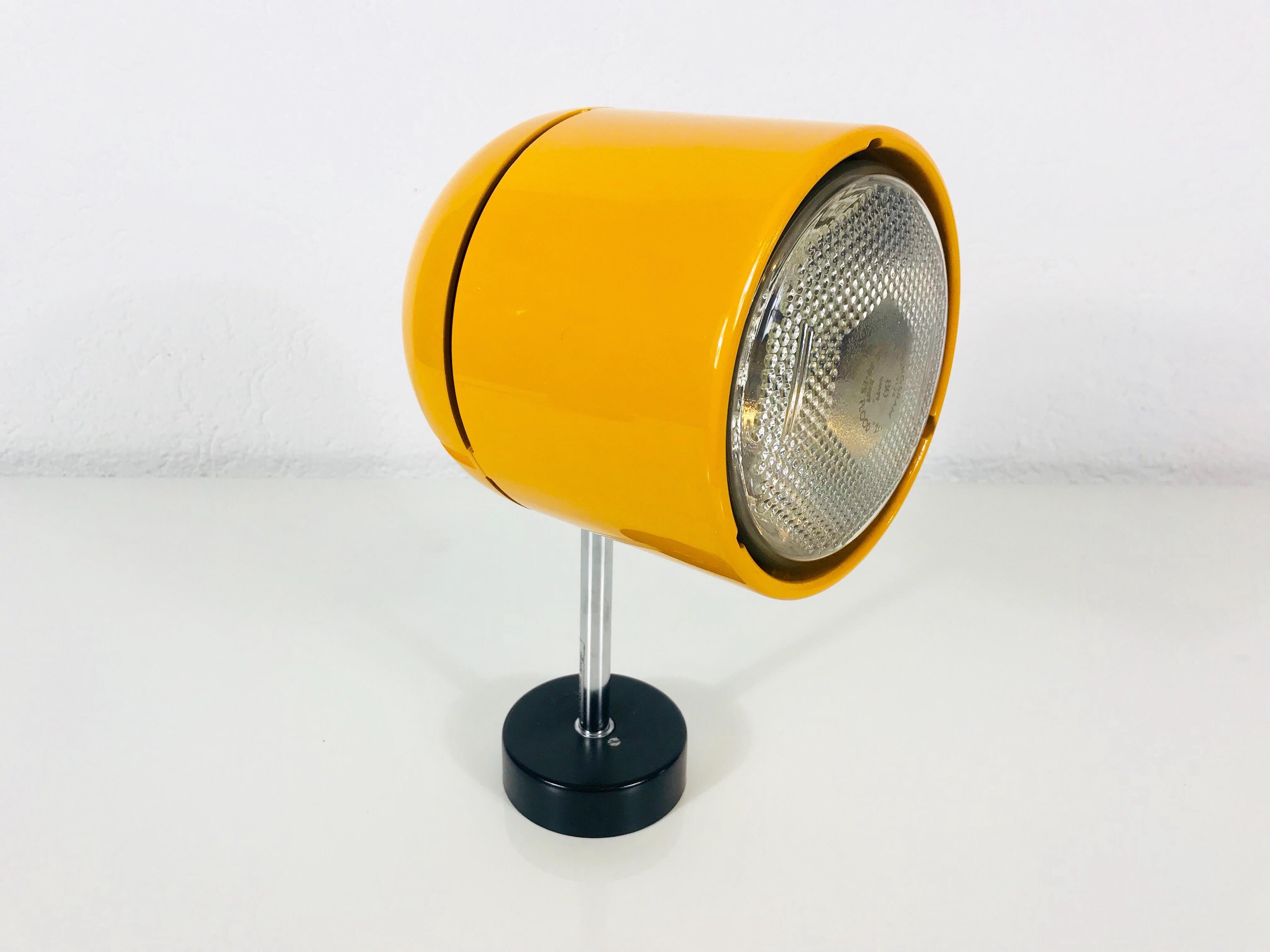 A spot light by Staff Leuchten made in Germany in the 1970s. It has a chrome metal bar with a black bakelit buttom. The top of the lamp has a beautiful orange color and is also metal. 

Measurements:

Height: 28 cm

Width: 14 cm

Depth: 16