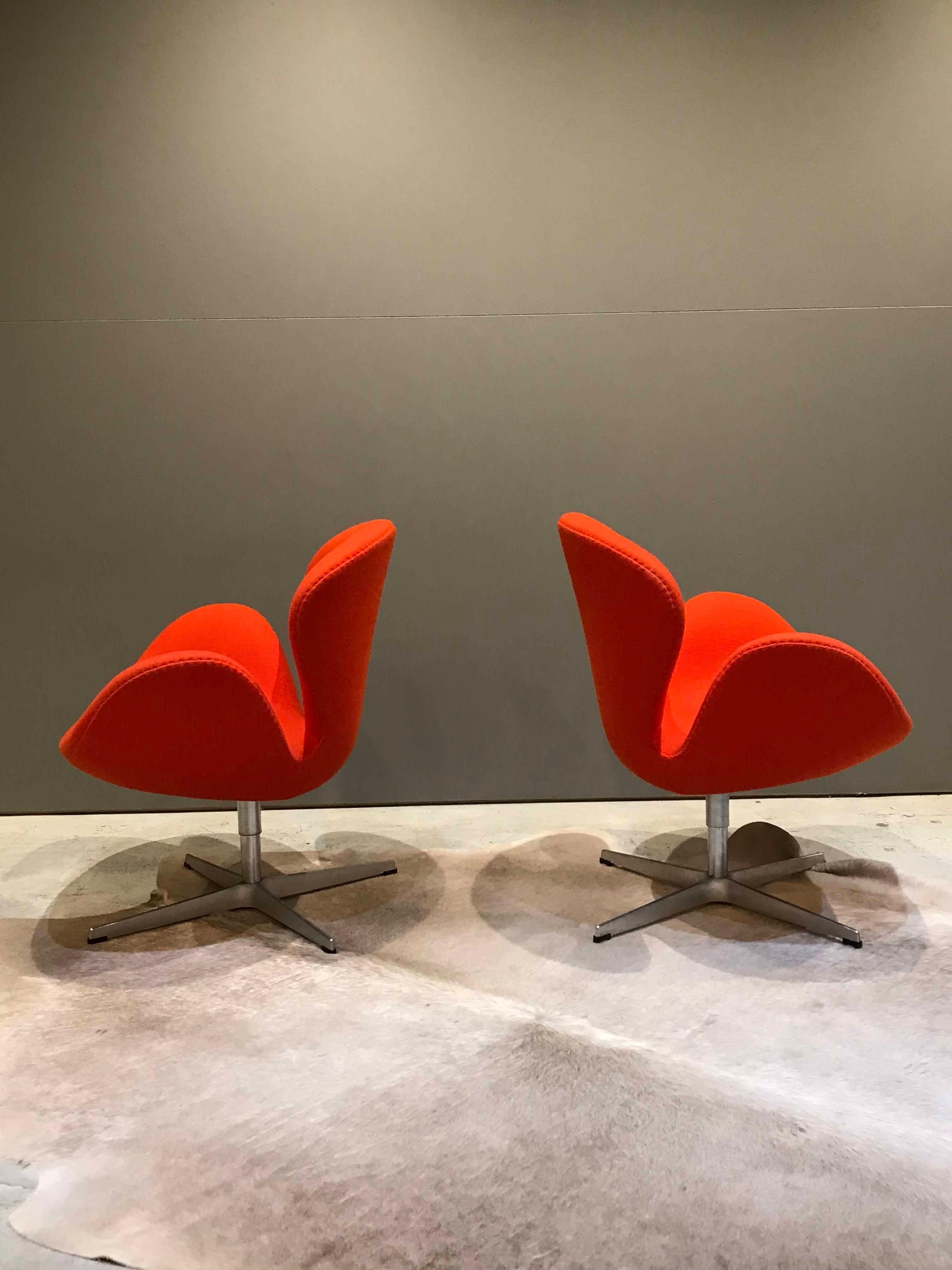Iconic swan chairs, originally designed by Arne Jacobsen in 1958 for the SAS Hotel, and now a design icon. This pair is in almost faultless condition with no stains or marks that I can see and barely visible wear, if any. They're covered in the