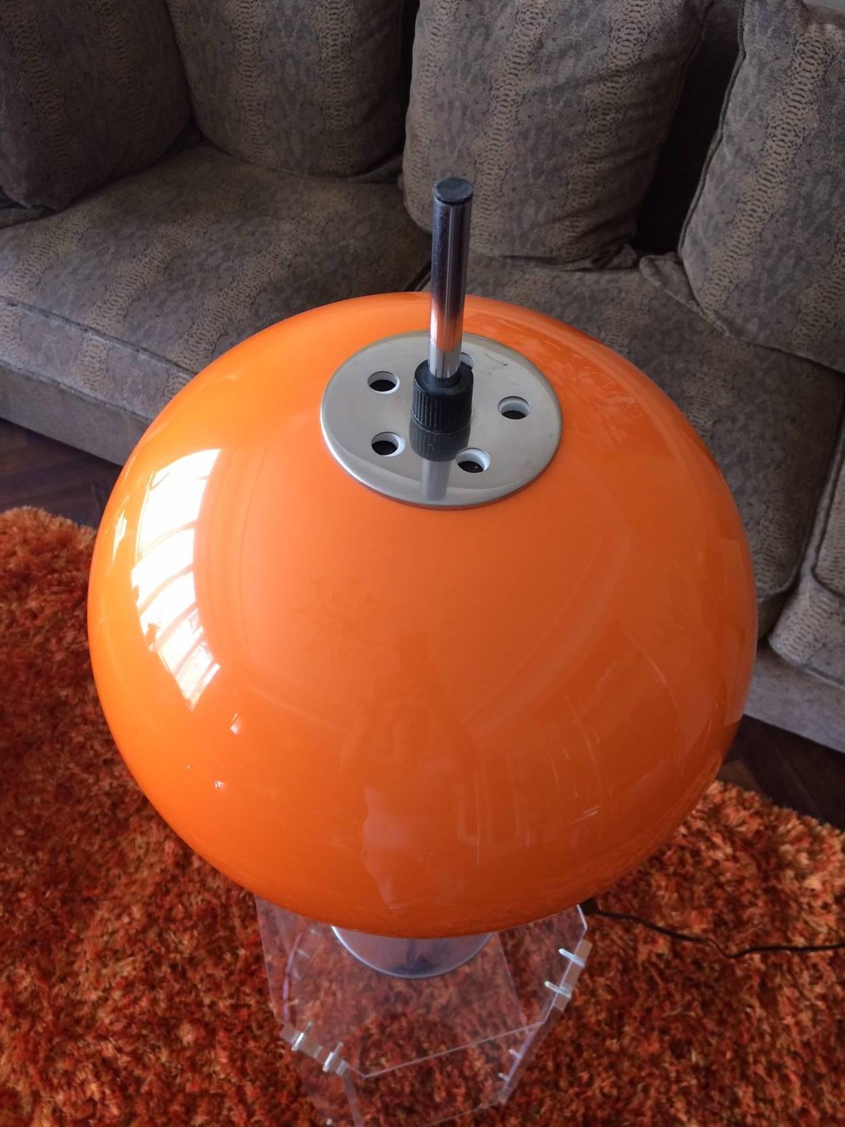Lampe de table vintage orange, lampe de table. 
Guzzini Italie.
Abat-jour en lucite orange sur base chromée. 
L'ombrage est réglable pour être placé haut ou bas.
Cet éclairage vintage orange convient à un intérieur moderne.
Un lampadaire Arc