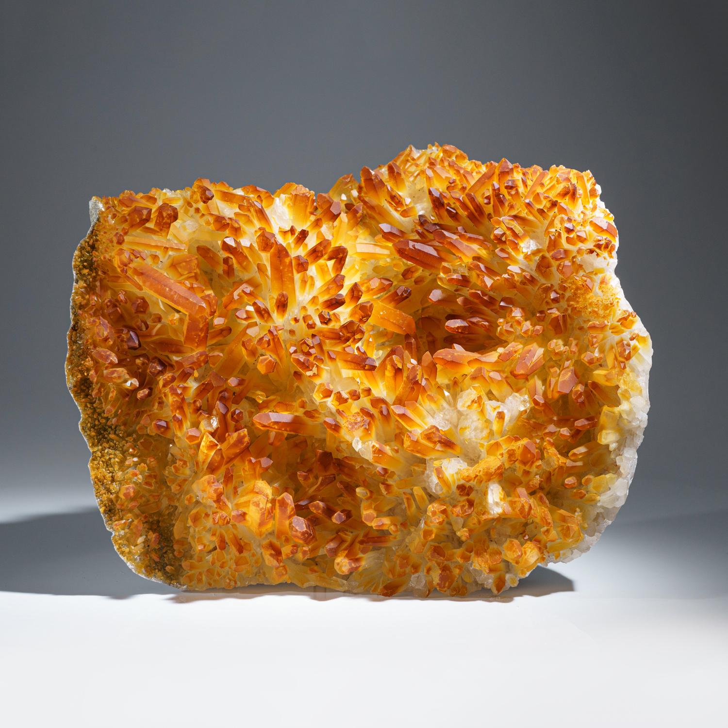A large cluster of rare orange tangerine quartz crystals. These rare quartz clusters are only found in this region of the world. A hemotite oxidate within the quartz has created the orange color. These specimens are all-natural, extremely rare and