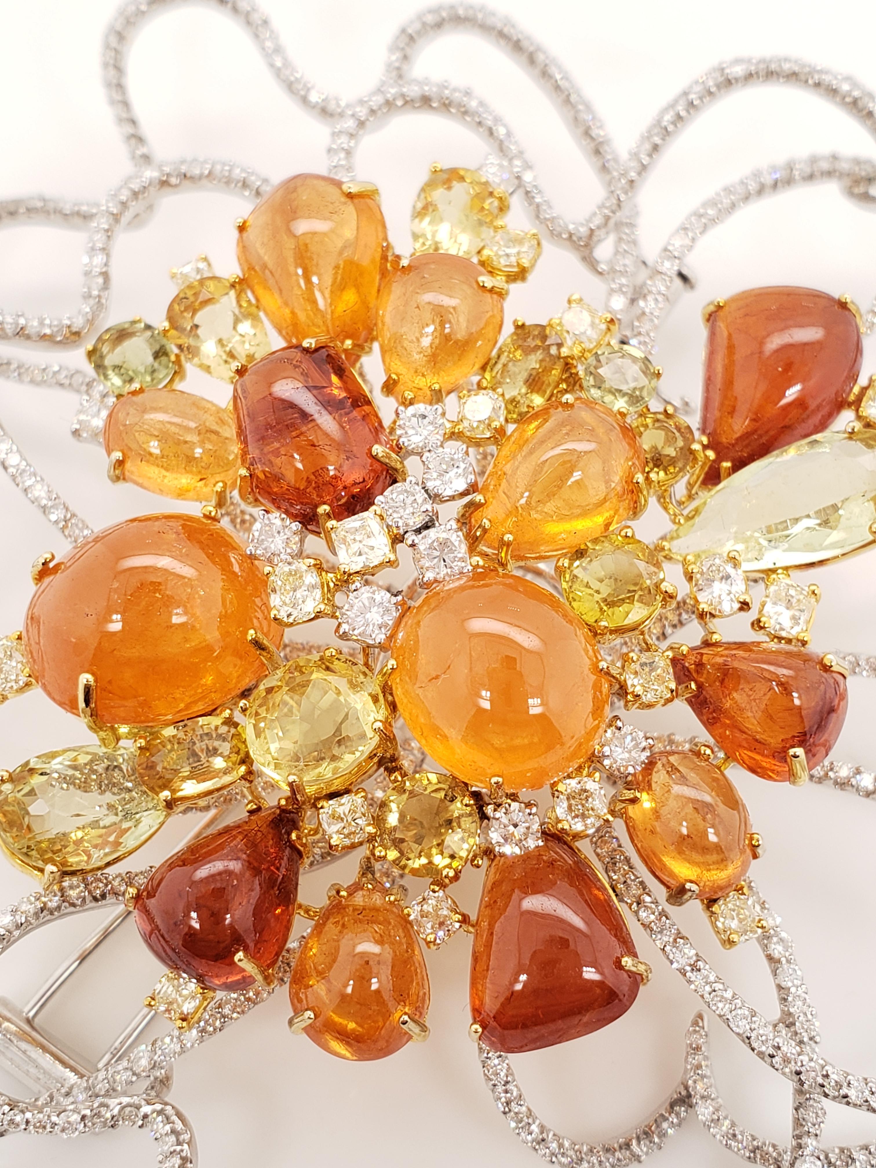 This magnificently colorful cluster brooch contains Orange Tourmaline, Hessonite, Garnet, Yellow Sapphire and approximately 10.00 carats of White diamonds on a delicate pavé wire. Hand-crafted in 18K White & Yellow Gold.

This one of a kind brooch
