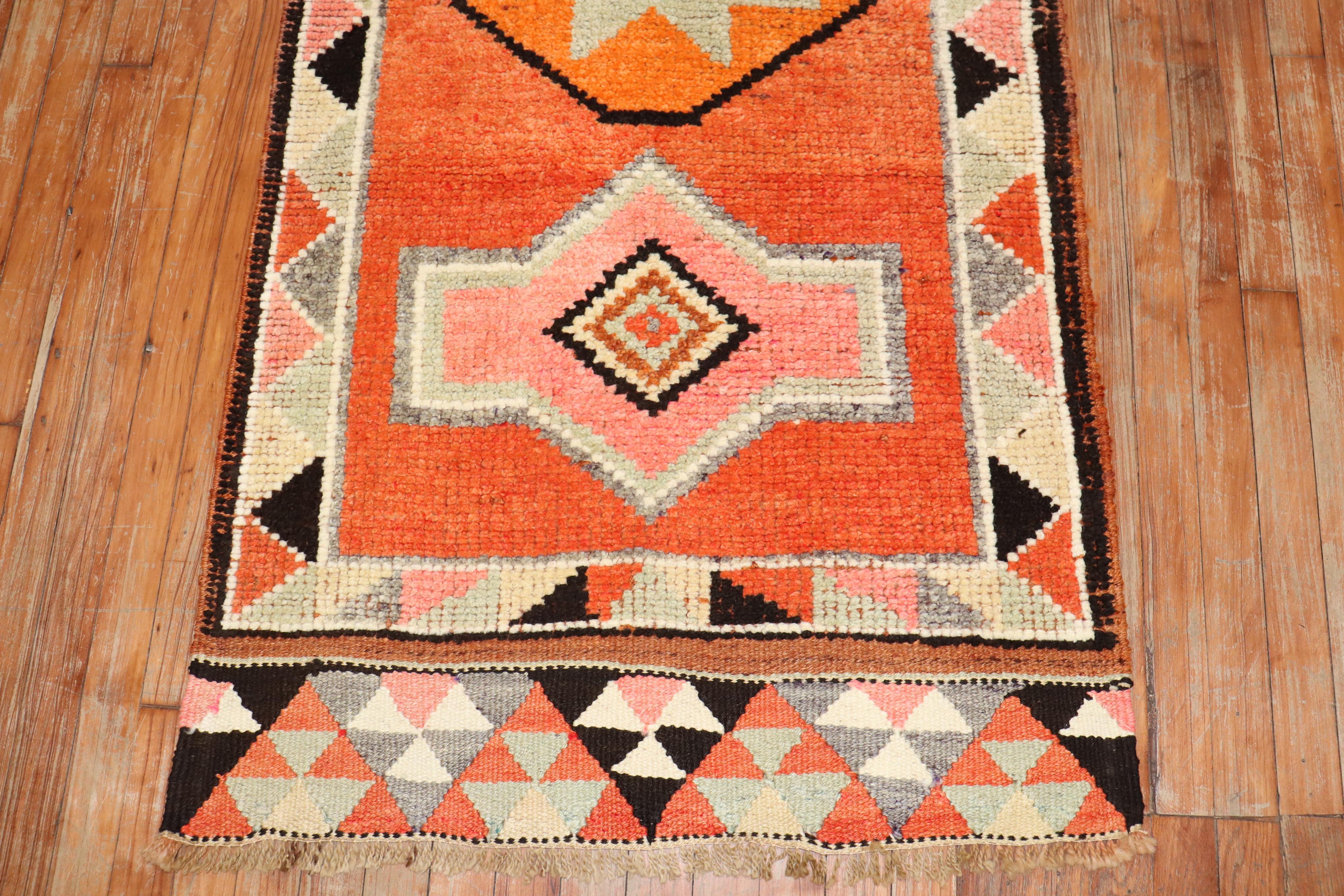 Mid 20th century tribal Turkish Anatolian runner with a tribal design in brown, orange, pink, and ivory dominant accents

Measures: 2'9