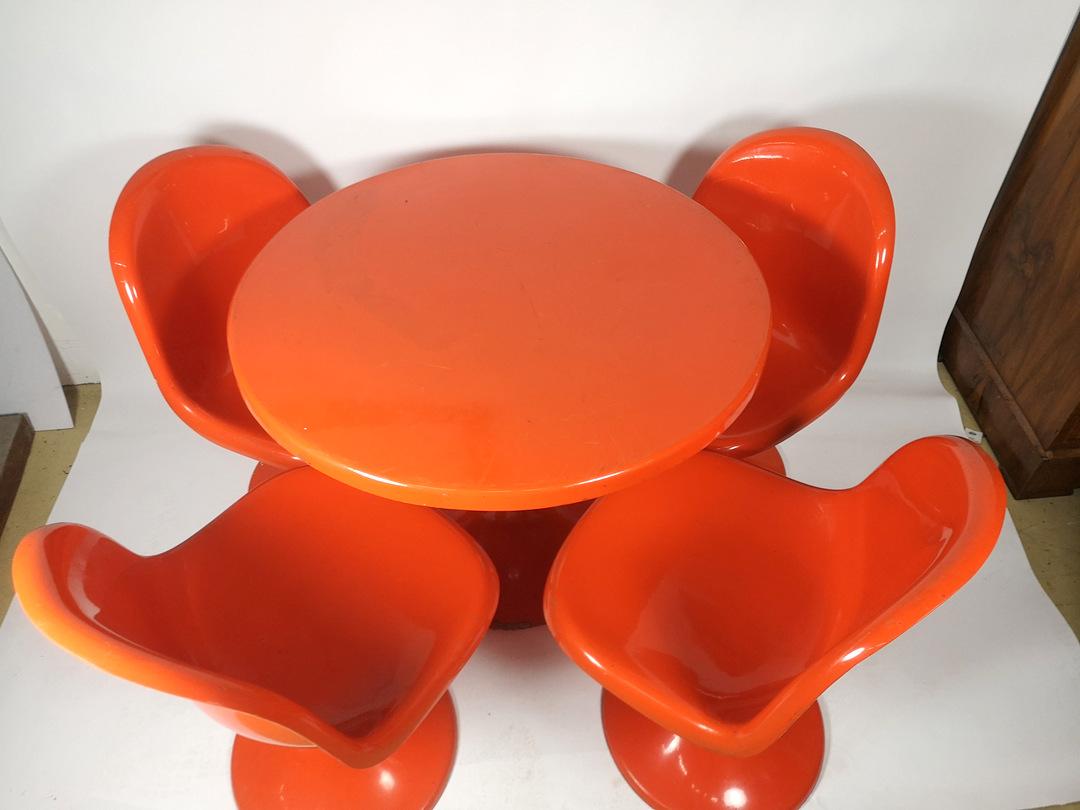 This orange/red painted fiberglass set of four chairs comes with its round table- it's a 1960s Hungarian product. Its size and material makes it perfect for outdoor use.
  