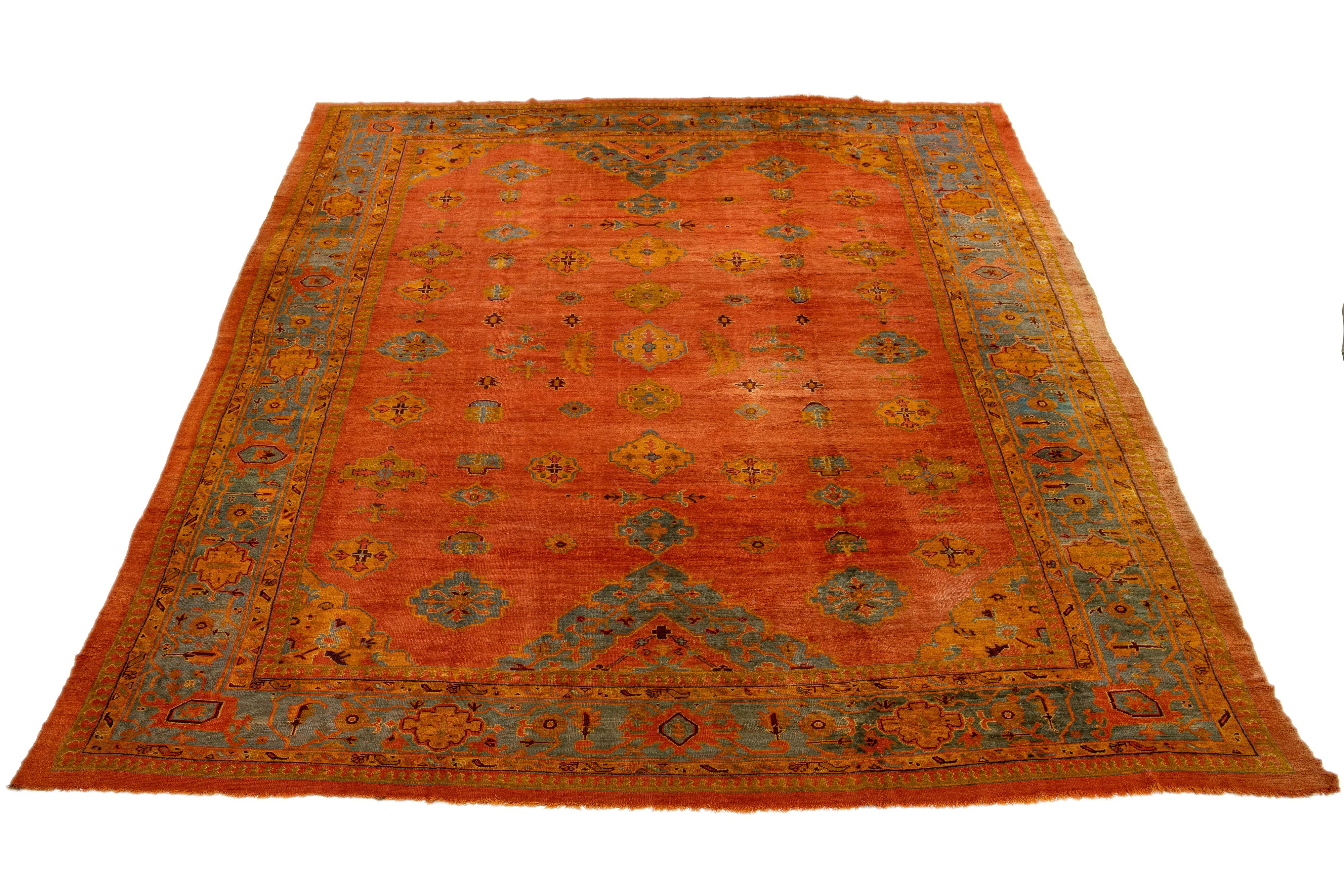 Dieser türkische Oushak-Teppich ist wirklich einmalig! Er ist aus weicher Wolle handgeknüpft und zeigt eine atemberaubende orangefarbene Farbgebung. Der Teppich zeigt ein wunderschönes Allover-Muster, das von einem dekorativen Rahmen umgeben ist,