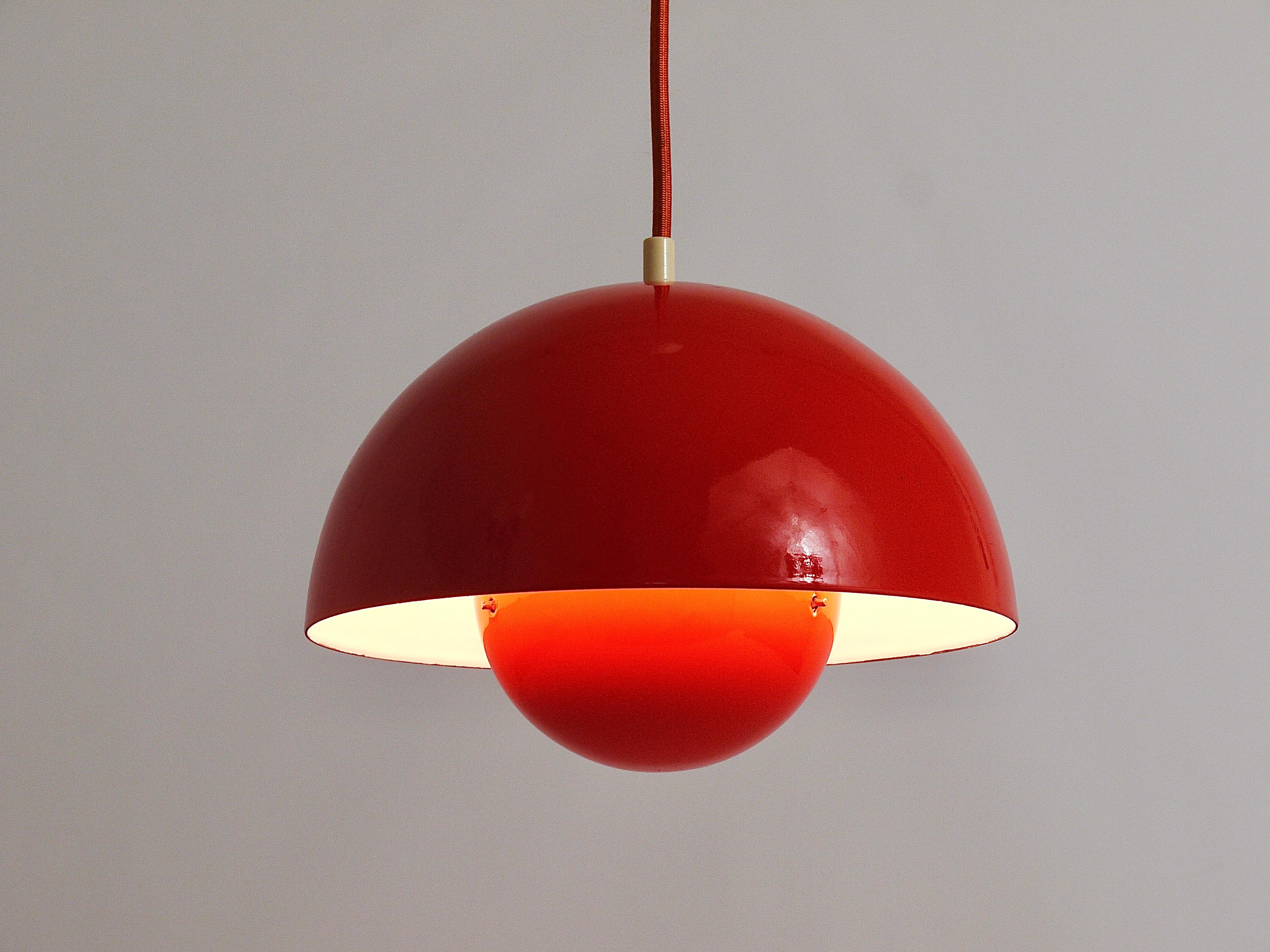 An iconic orange flowerpot pendant light, designed in 1969 by Verner Panton for Louis Pulsen, Denmark. A simple but beautiful ceiling light, consisting of two enameled hemispherical lampshades facing each other. The lower lampshade has a red
