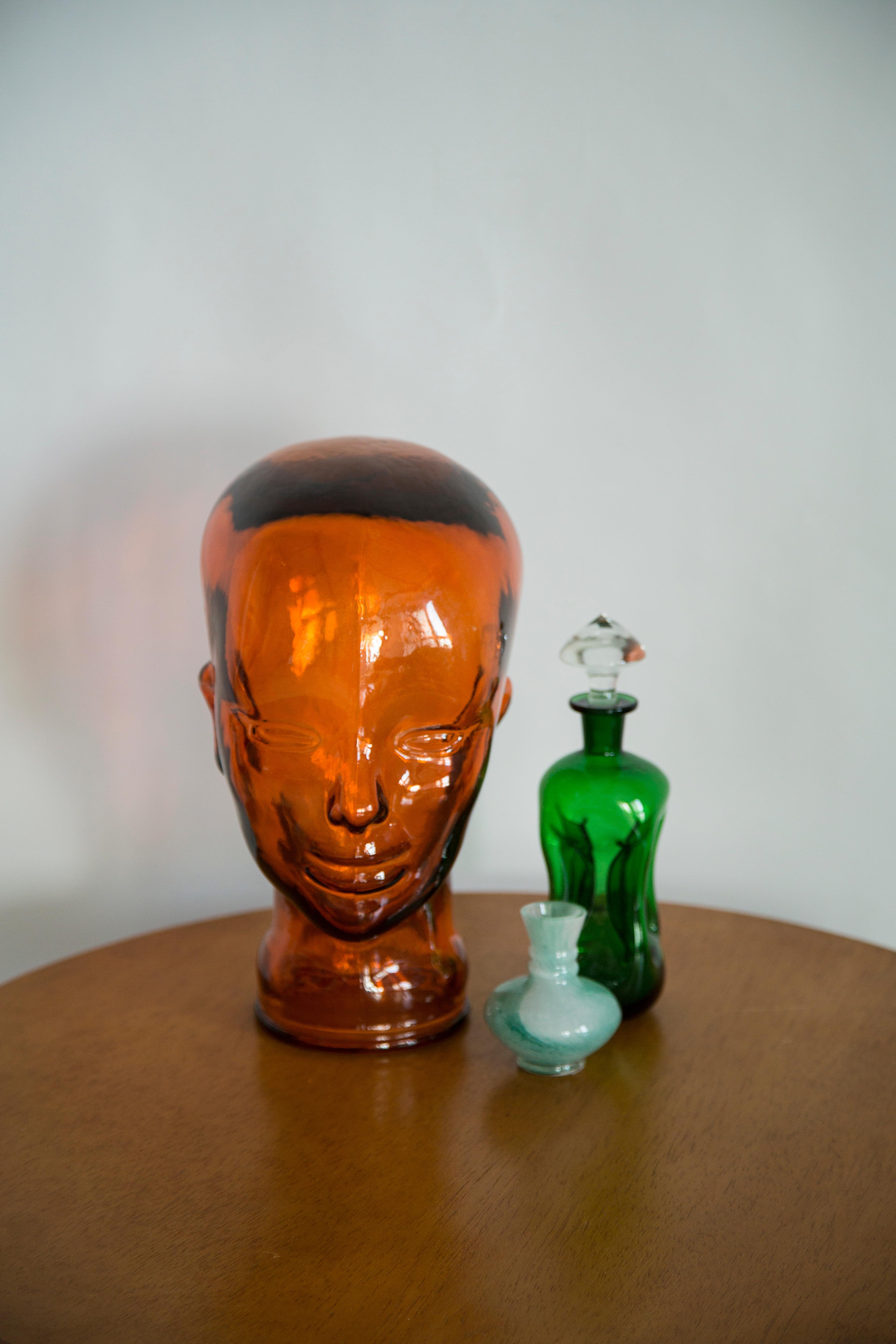 Cabeza de cristal de tamaño natural en un color naranja único. Fabricado en una cristalería alemana en la década de 1970. Perfecto estado. Un complemento perfecto para el interior, accesorio fotográfico, expositor o soporte para auriculares.