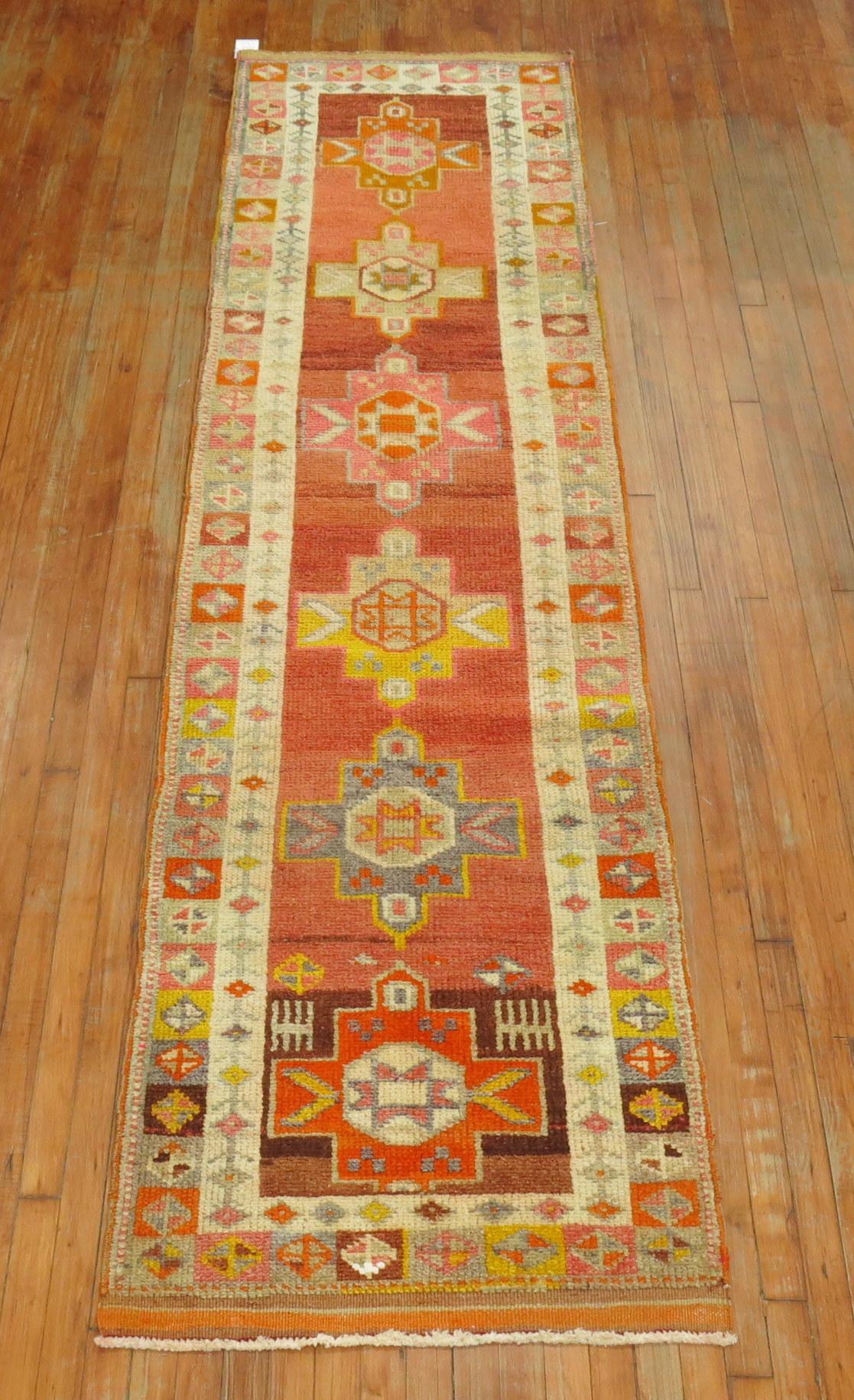 Turkish Anatolian runner with a geometric medallion design on a coral orange field.
