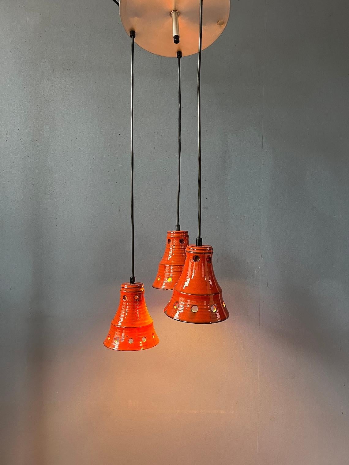 Orange west germany cascade chandelier with three triangle-shaped ceramic lights. The height of each individual light can easily be adjusted, the pictures show just one possible example. The lamp requires three E27/26 (standard)
