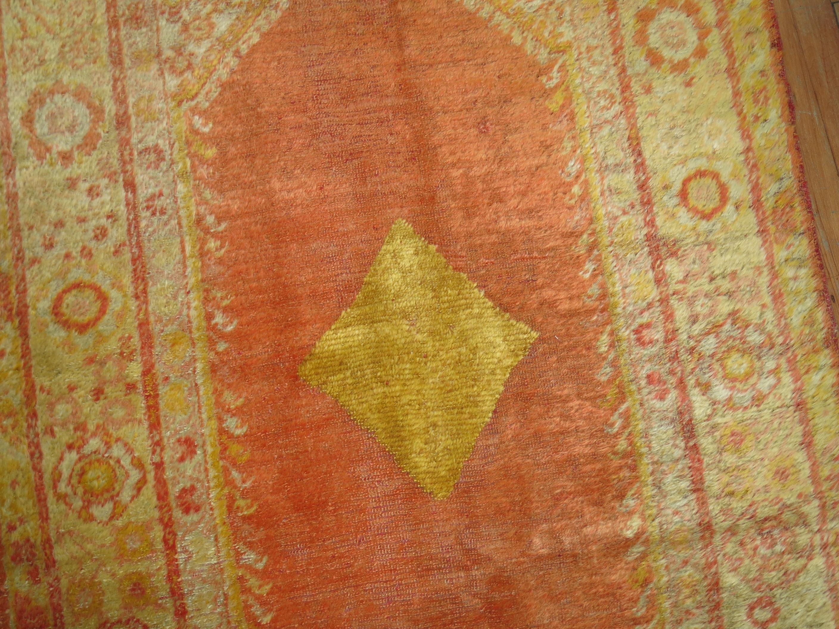 An early 20th century angora wool Oushak rug with a orange peel field accents in honey, warm red and ivory. This is a genuine piece woven with angora goat wool and its an antique. There is no noticeable repairs or any significant condition issues at