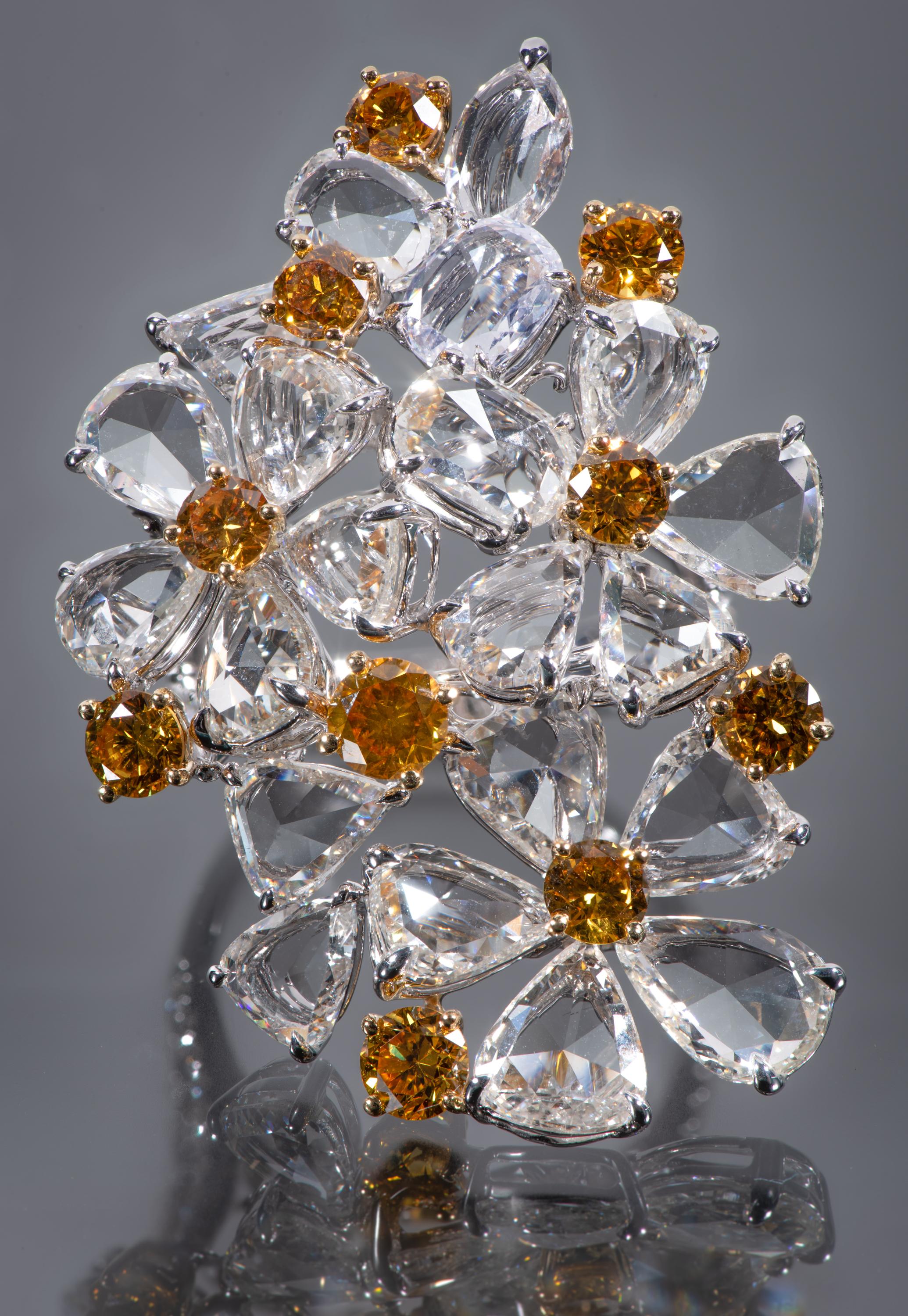 A cascade of 21 pear, triangle and oval shaped diamonds create the petals and leaves in this unusual flower bouquet ring. Ten round brilliant-cut 