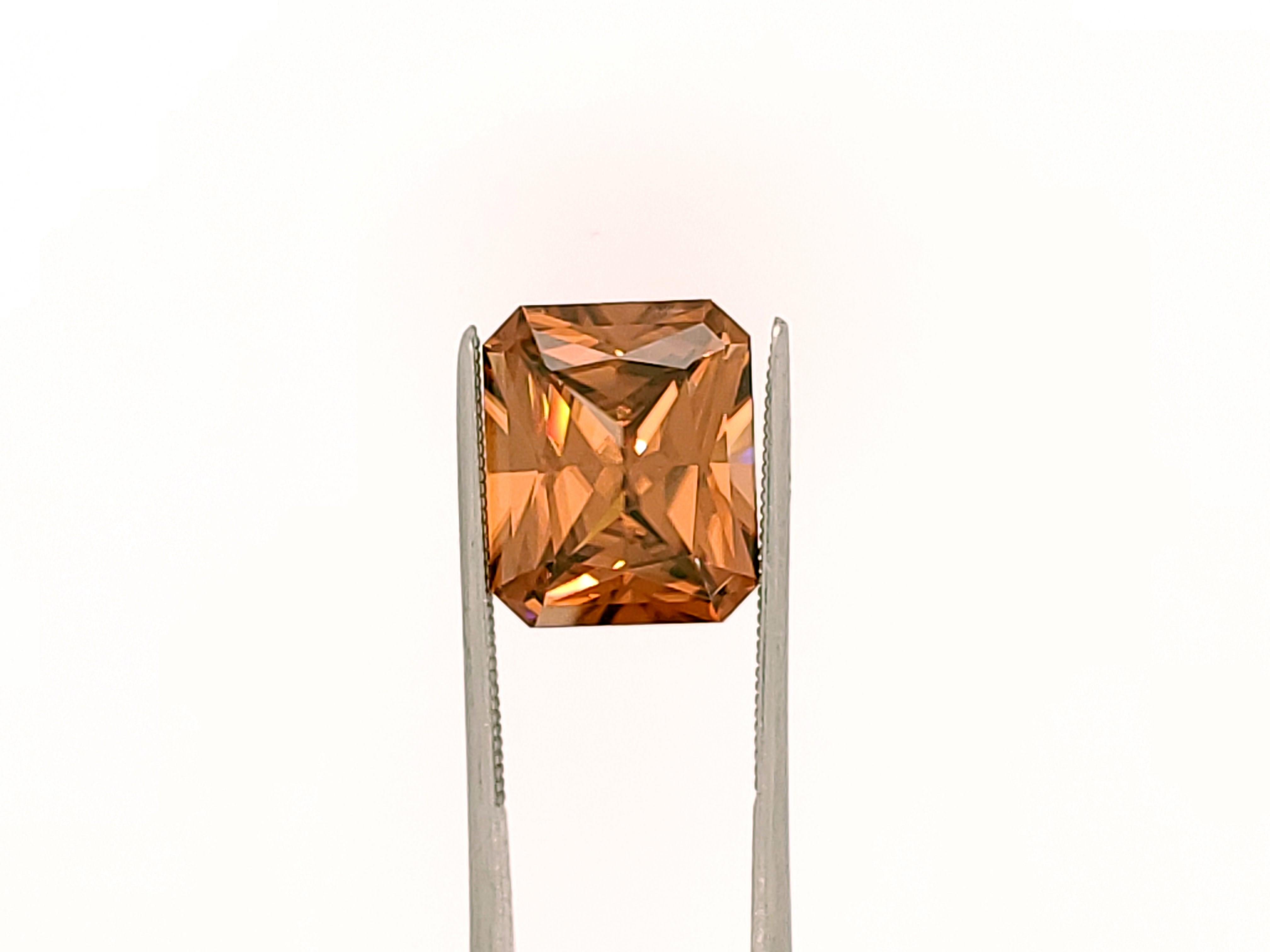 This 8.71 carat Orange Zircon was faceted from our rough by a cutter we use who is located in the United States.  It measures approx 12x10mm. Photo was modified a bit to tone down the orange as the camera photographed a much more intense Orange.