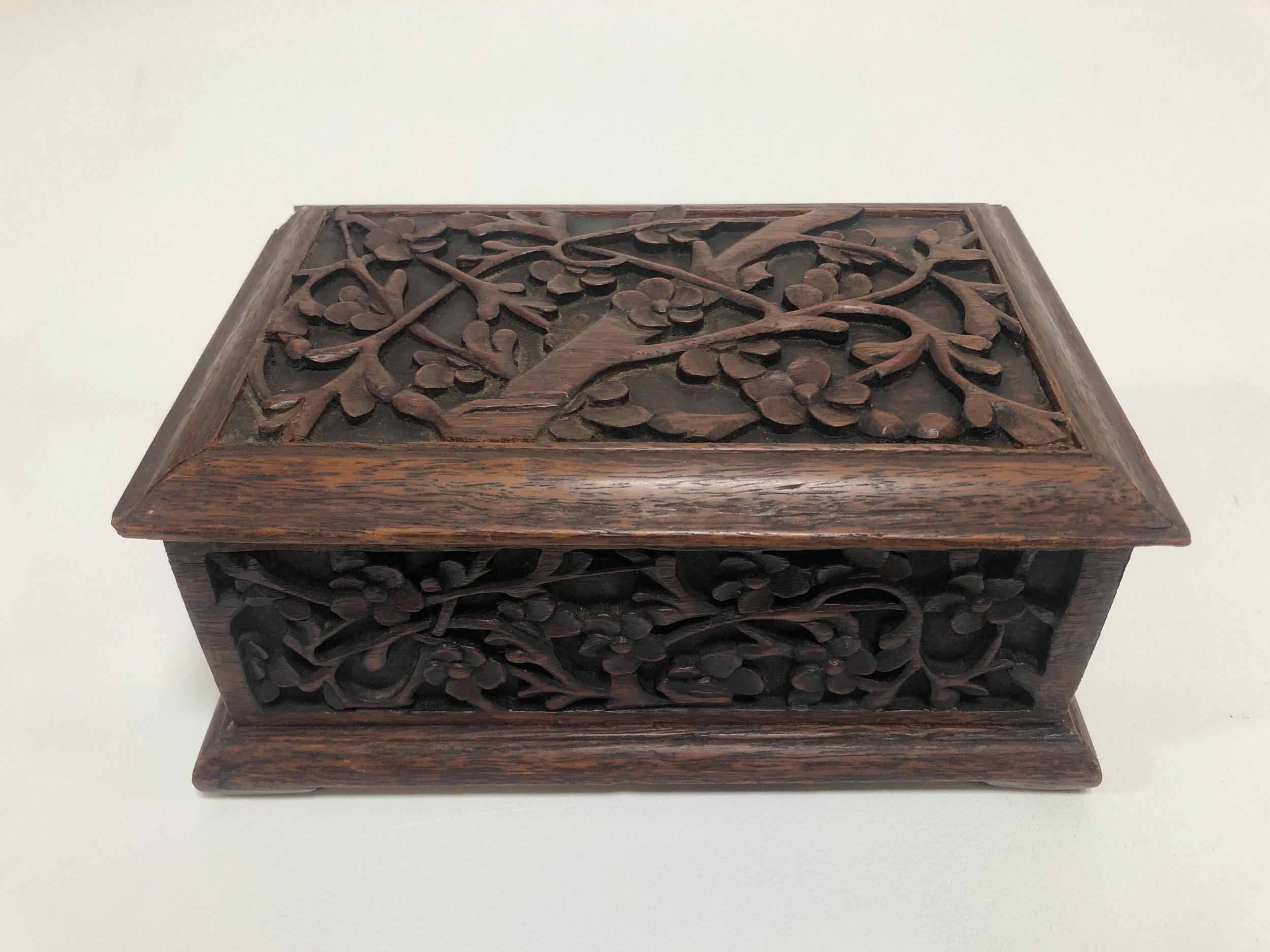This is a beautifully hand-carved rosewood keepsake or jewelry box from the 1920's. It features a lovely floral pattern on all four sides of the box and the lid. The lid is completely removable with no hinges.