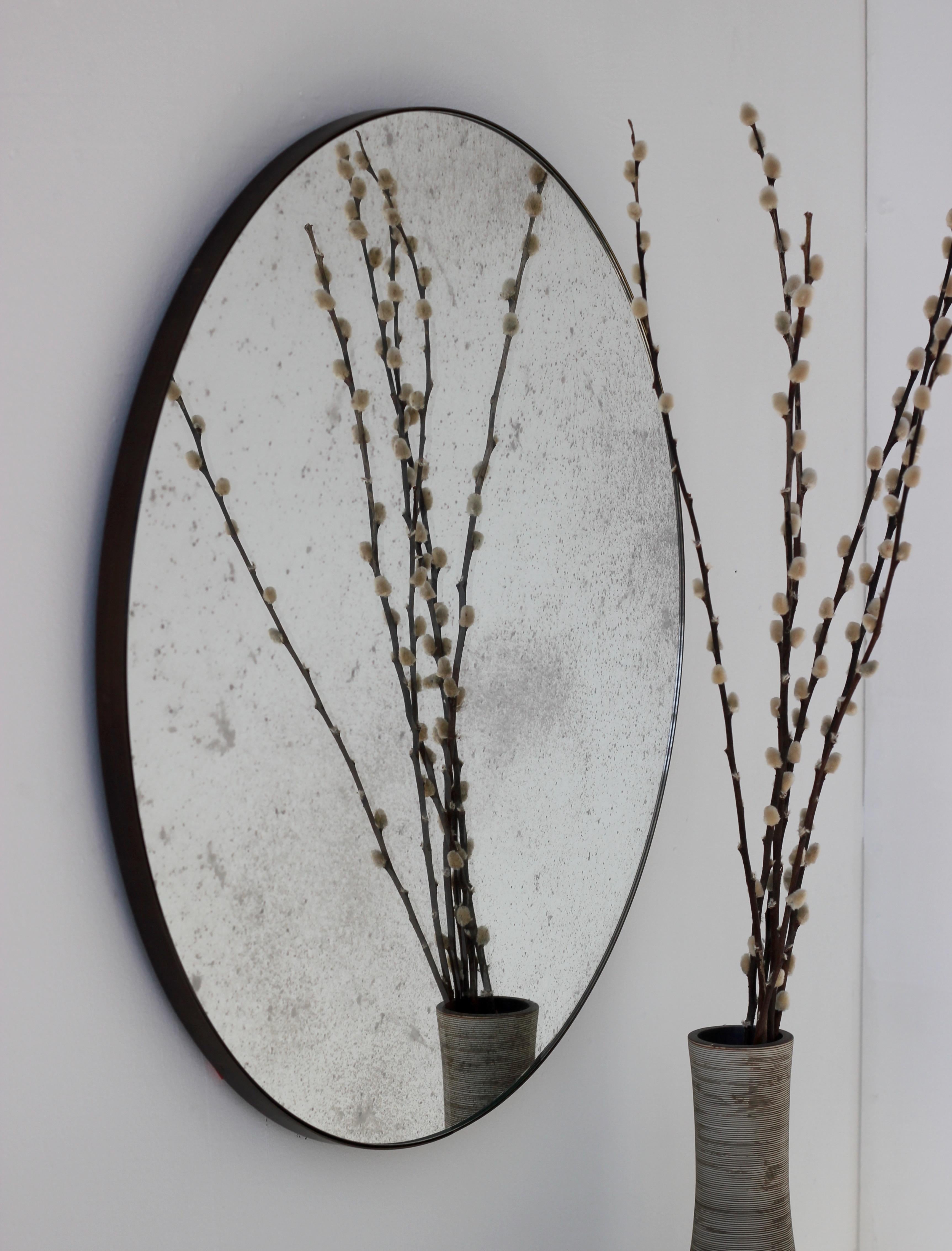 Delightful antiqued Orbis™ round mirror with an elegant brass patina frame.  The detailing and finish, including visible brass patinated screws, emphasise the crafty and quality feel of the mirror, a true signature of our brand. Designed and