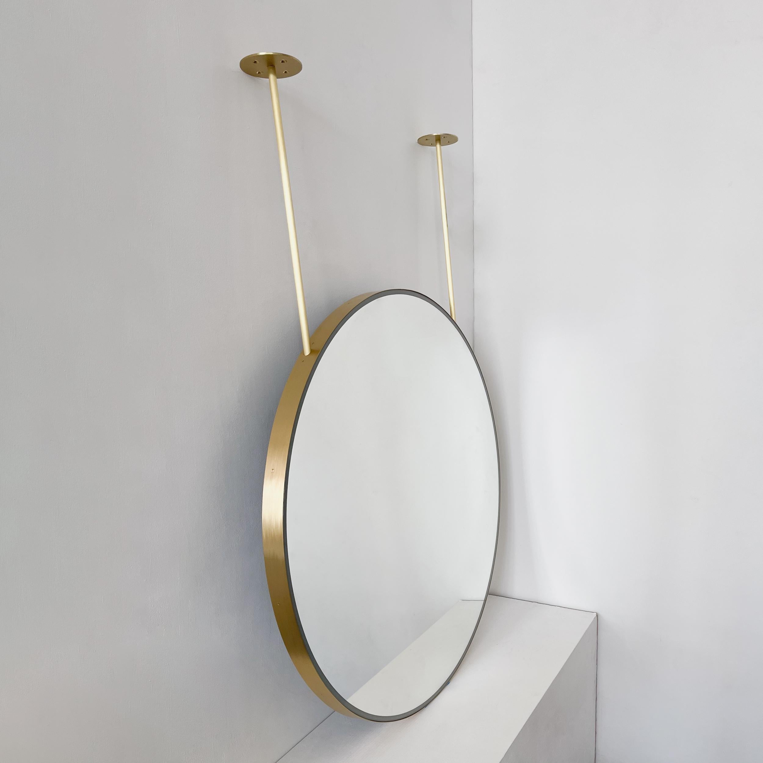 Contemporary front illuminated ceiling suspended Orbis™ round mirror with a handcrafted solid brushed brass frame and two arms. Designed and handcrafted in London, UK. This mirror is fully customisable to suit the specific requirements of each