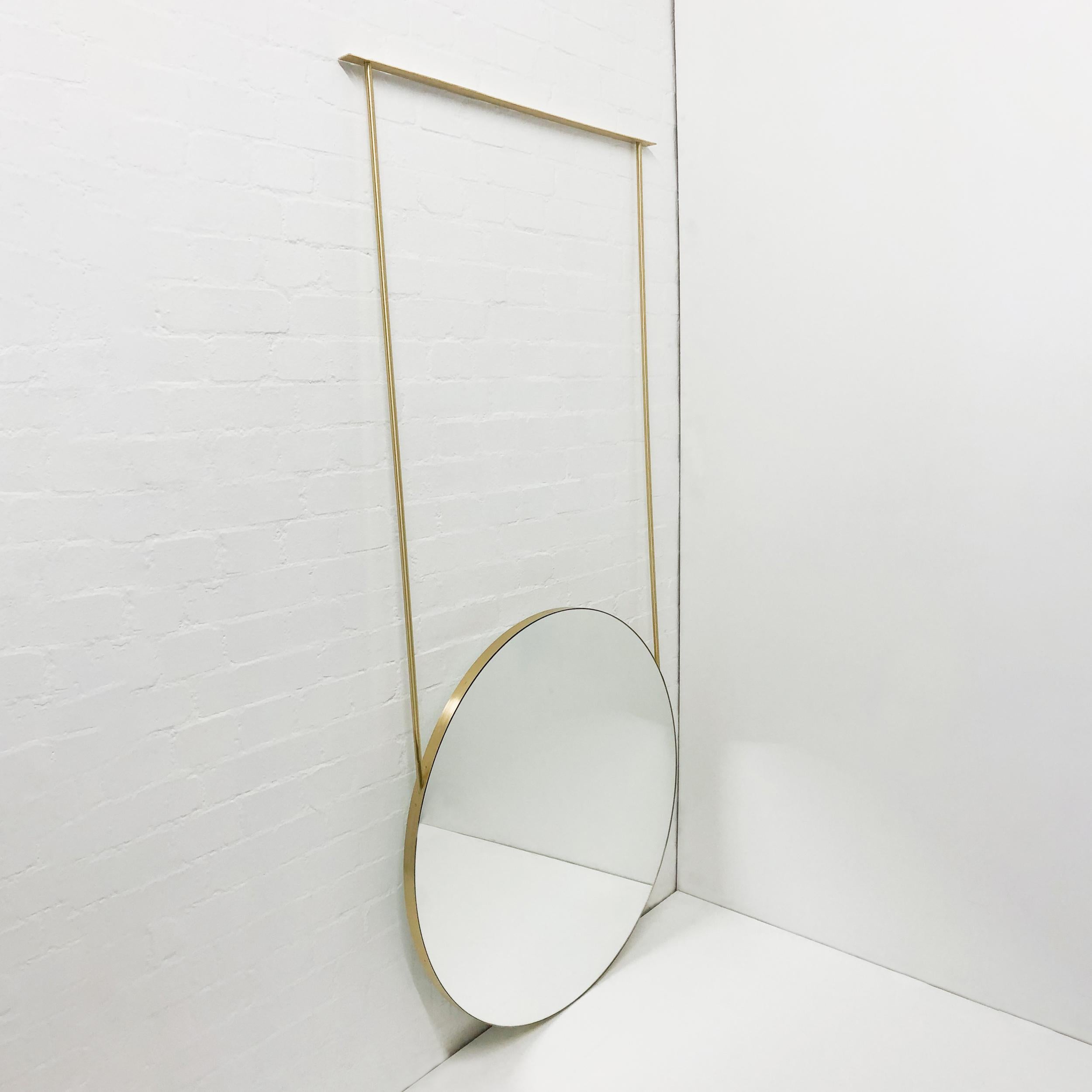 Modern ceiling suspended Orbis™ round mirror with a minimalist solid brushed brass frame and a black panel backing.

Our unique collections of ceiling suspended mirrors are designed and handcrafted in London, UK, and are therefore fully customisable