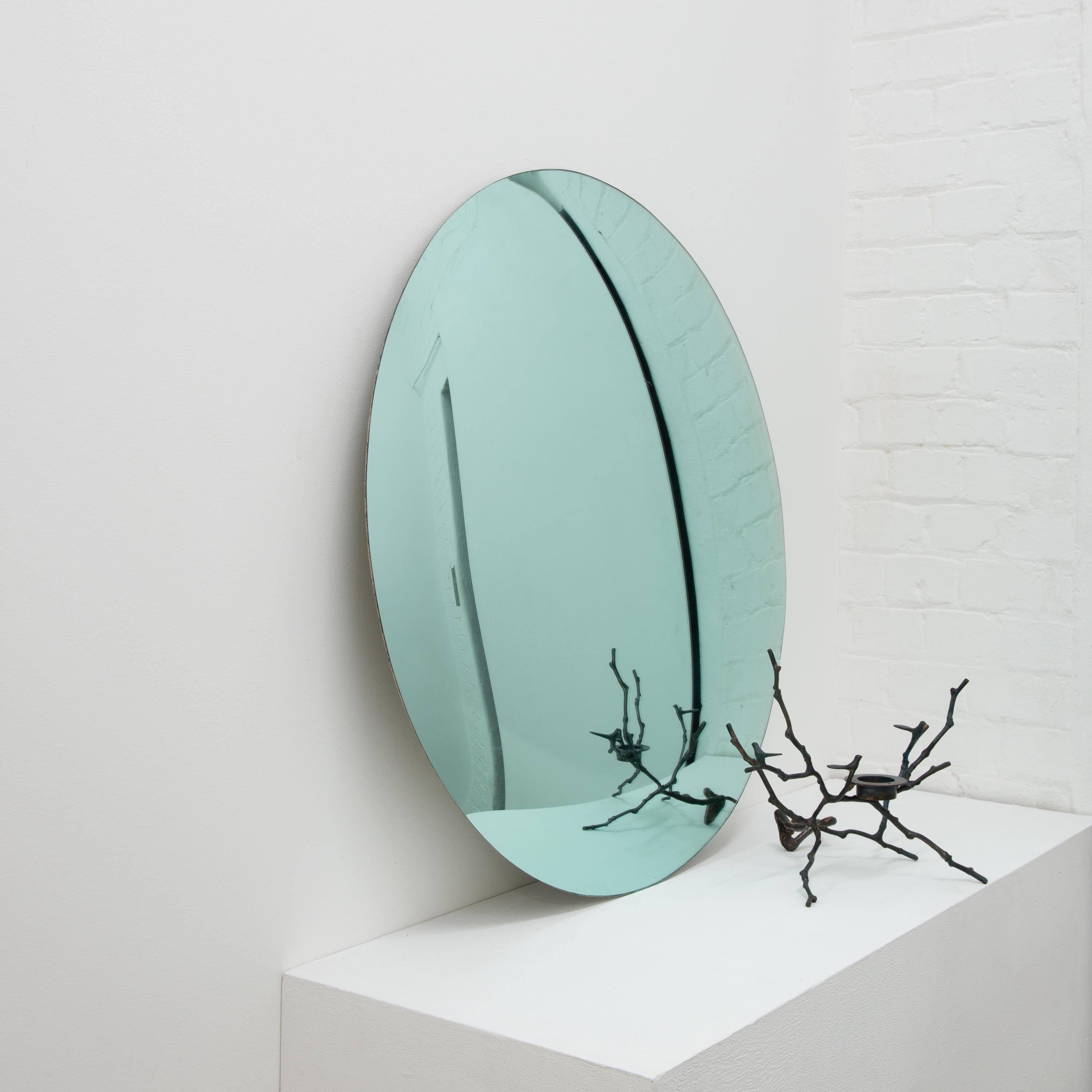 Contemporary green tinted convex frameless mirror.

Each Orbis™ convex mirror is designed and handcrafted in London, UK. Slight variations in sizes and imperfections on edges and surface finishes are characteristics of such original handmade