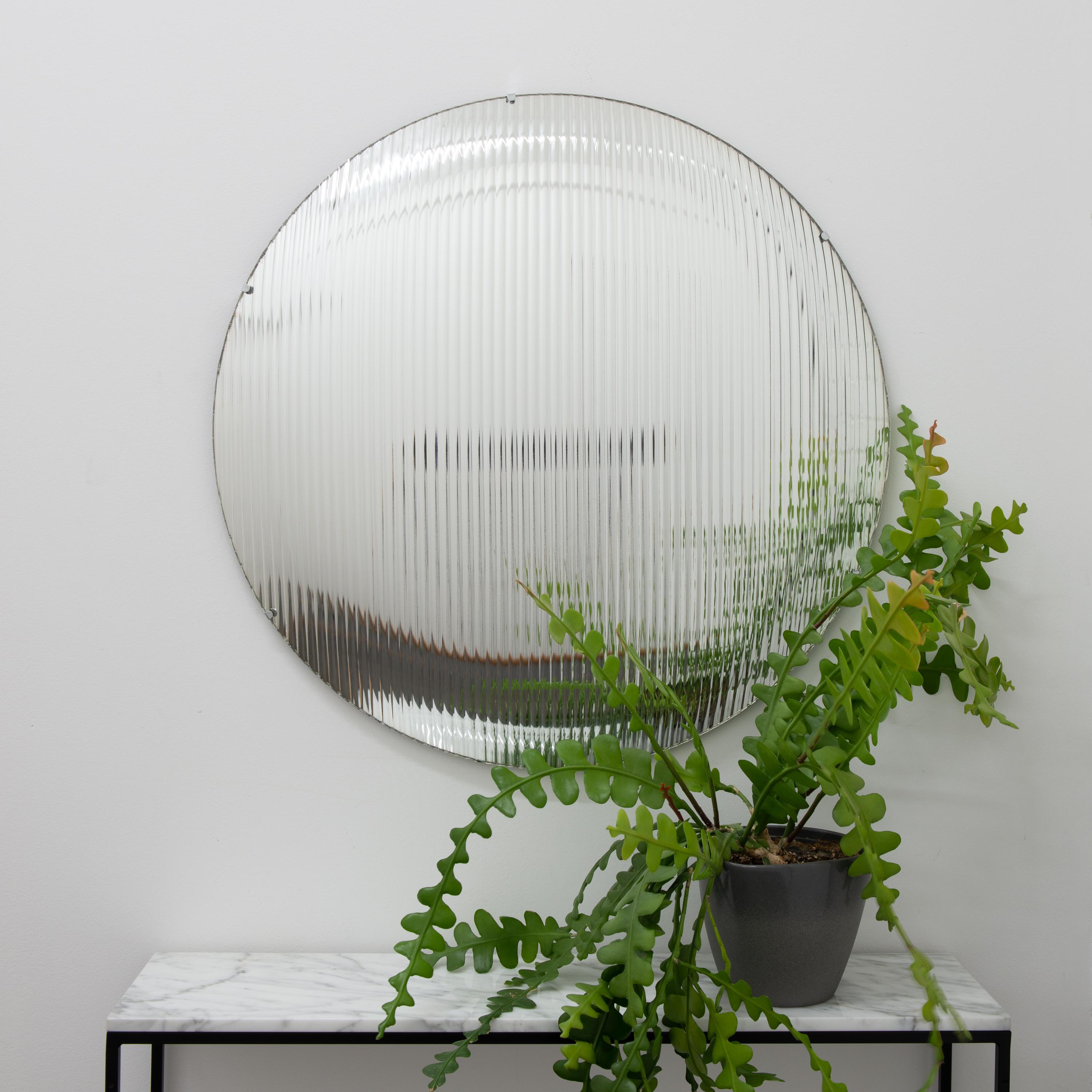 Stunning reeded glass round convex frameless mirror with stainless steel clips.

Each Orbis™ convex mirror is designed and handcrafted in London, UK. Slight variations in sizes and imperfections on edges and surface finishes are characteristics of