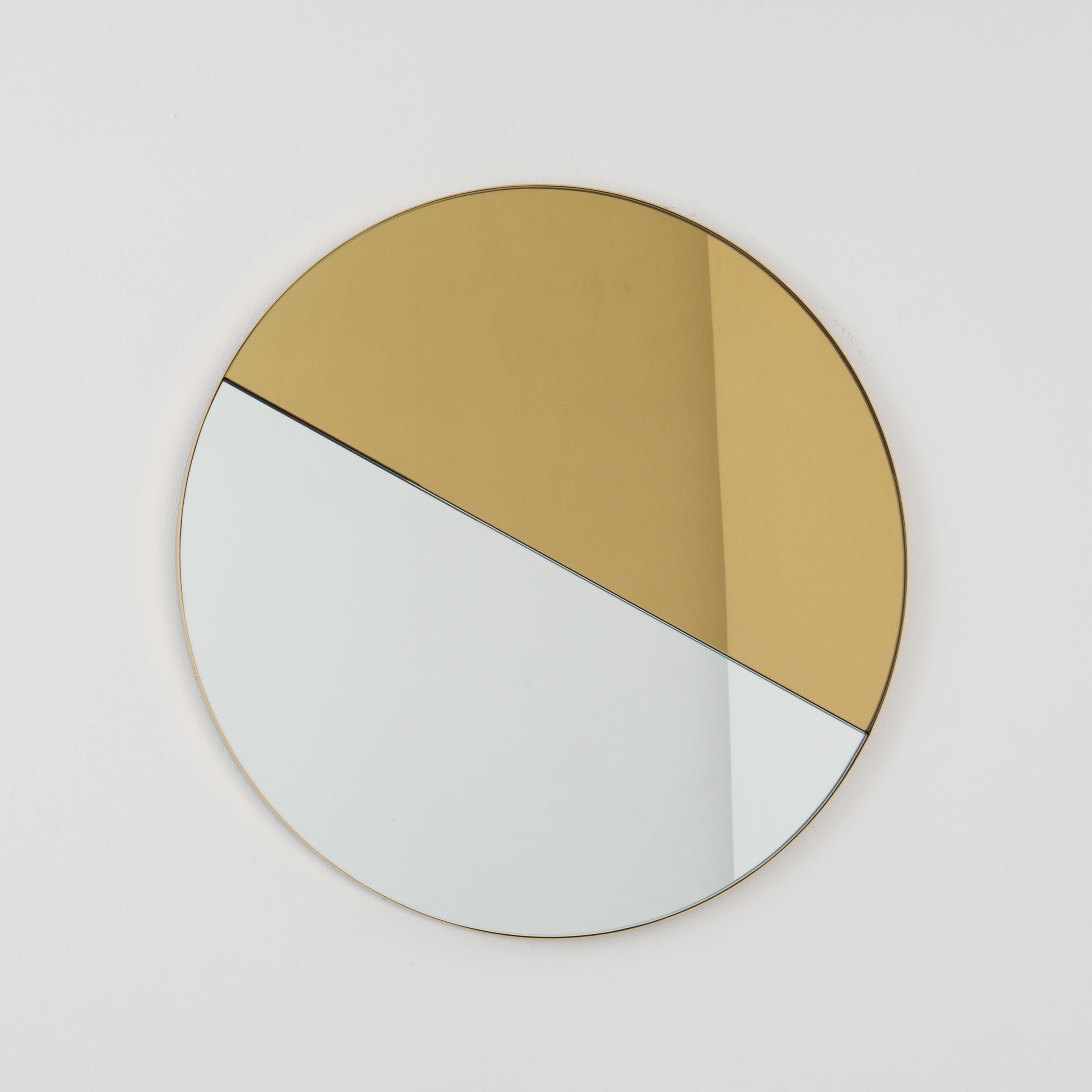 Delightful handcrafted mixed tinted gold and silver Orbis Dualis mirror with an elegant solid brushed brass frame. Supplied fully fitted with a specialist hanging system that allows the mirror to be hung in four different positions. Designed and