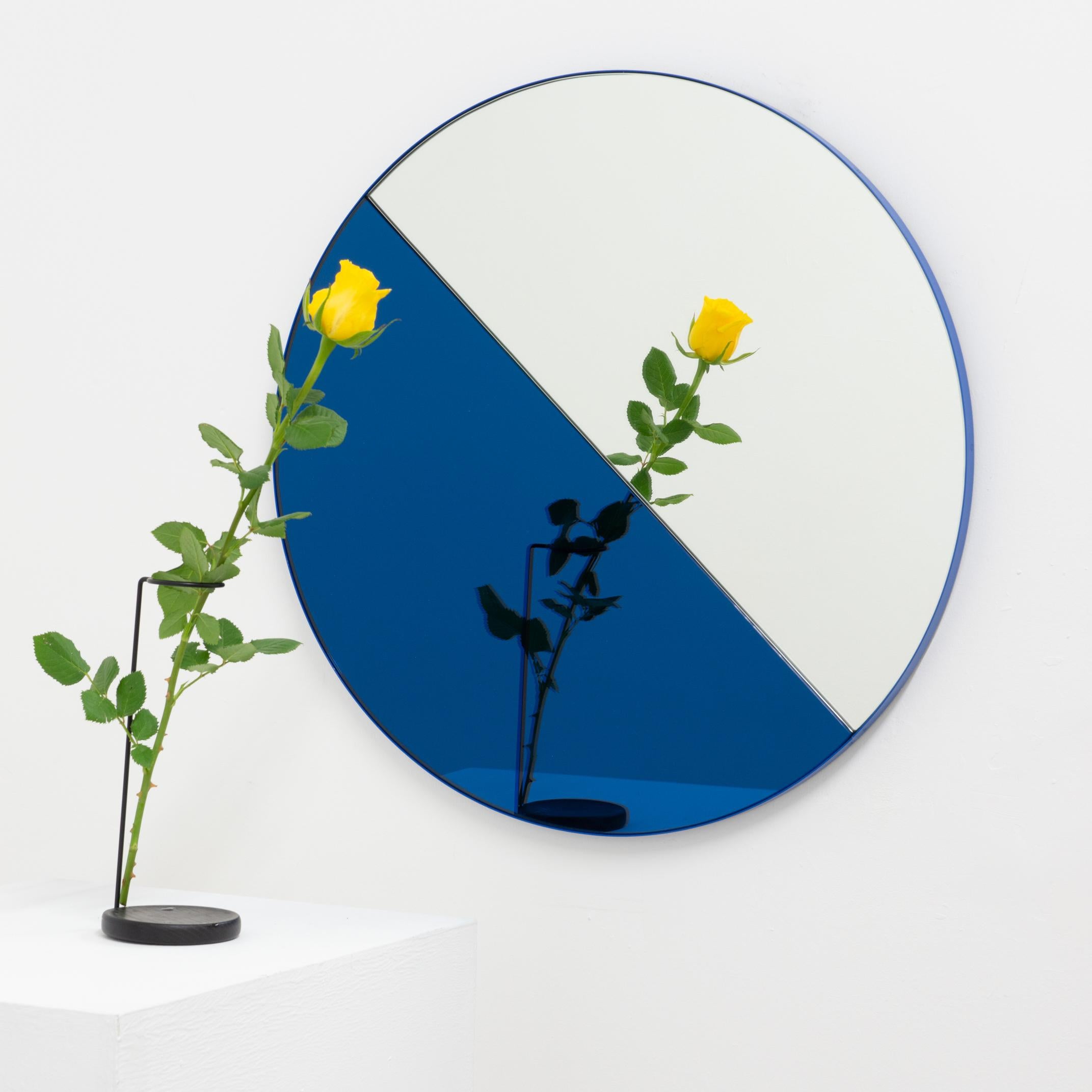 Contemporary mixed blue and silver mirror tints Dualis Orbis with a blue frame. Designed and handcrafted in London, UK.

All mirrors are fitted with an ingenious French cleat (split batten) system so they may hang flush with the wall in four