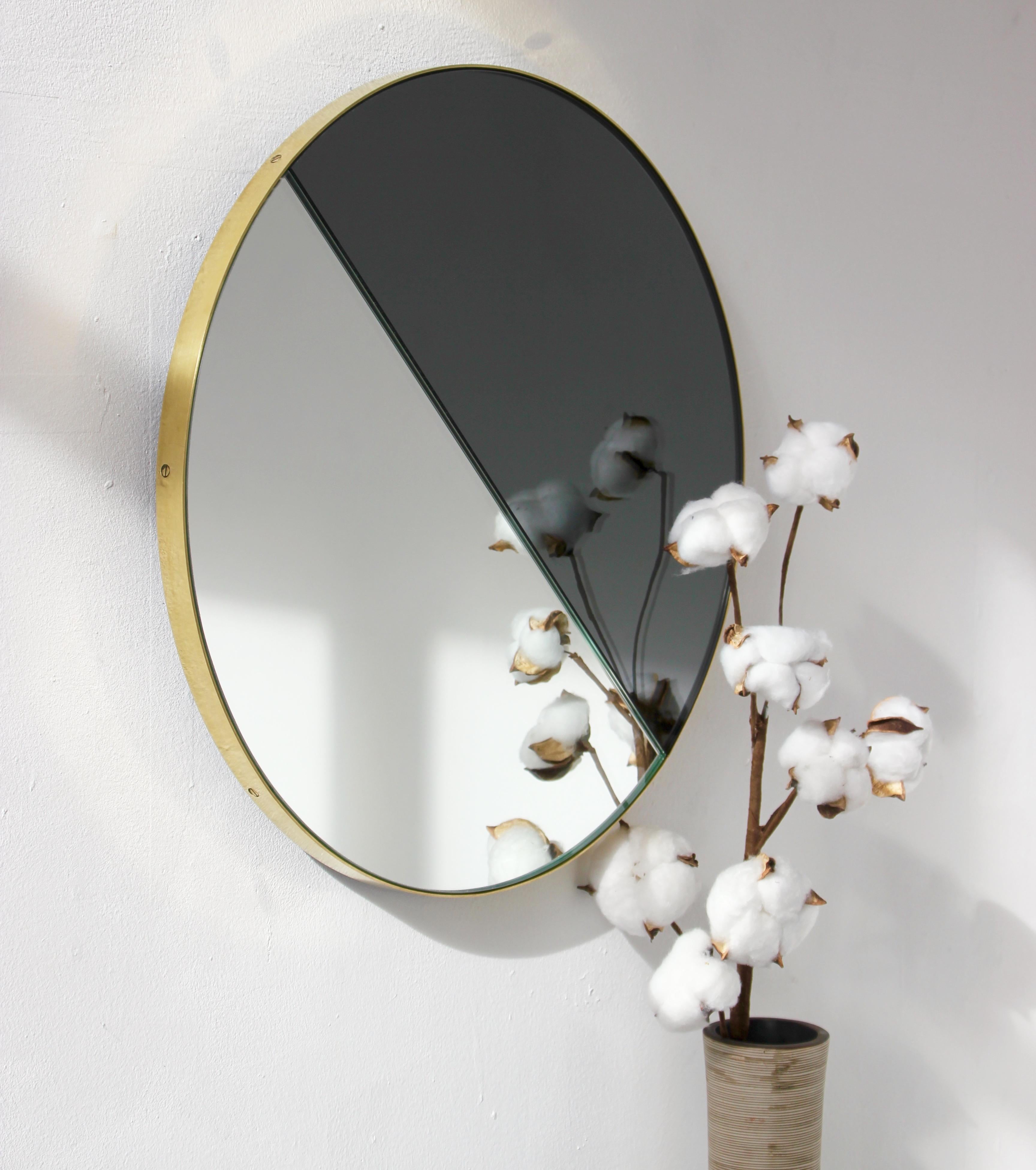 Contemporary mixed bronze and silver mirror tints Dualis Orbis with a brushed brass frame. Designed and handcrafted in London, UK.

Fitted with a specialist hanging system that allows the mirror to be hung in four different positions.

This mirror