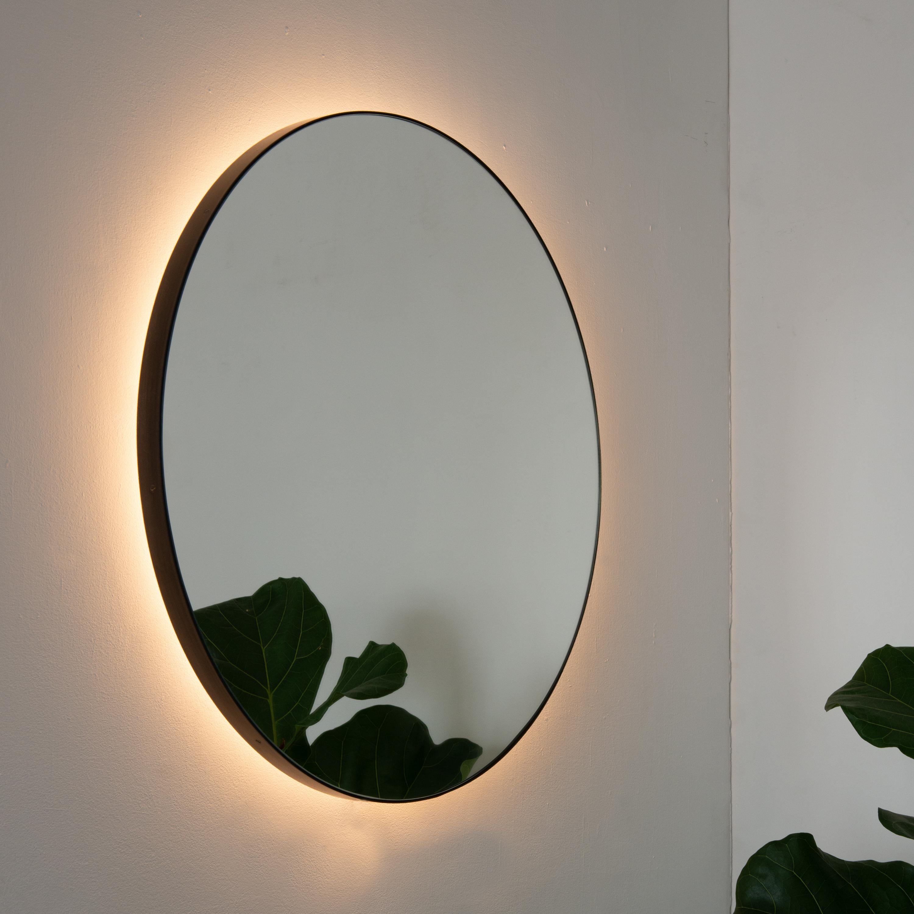 This item is available now at a special 20% discount. It may be packed and shipped within 3 days of receiving an order.

Minimalist round mirror with an elegant bronze patina brass frame and back illumination. Designed and handcrafted in London,