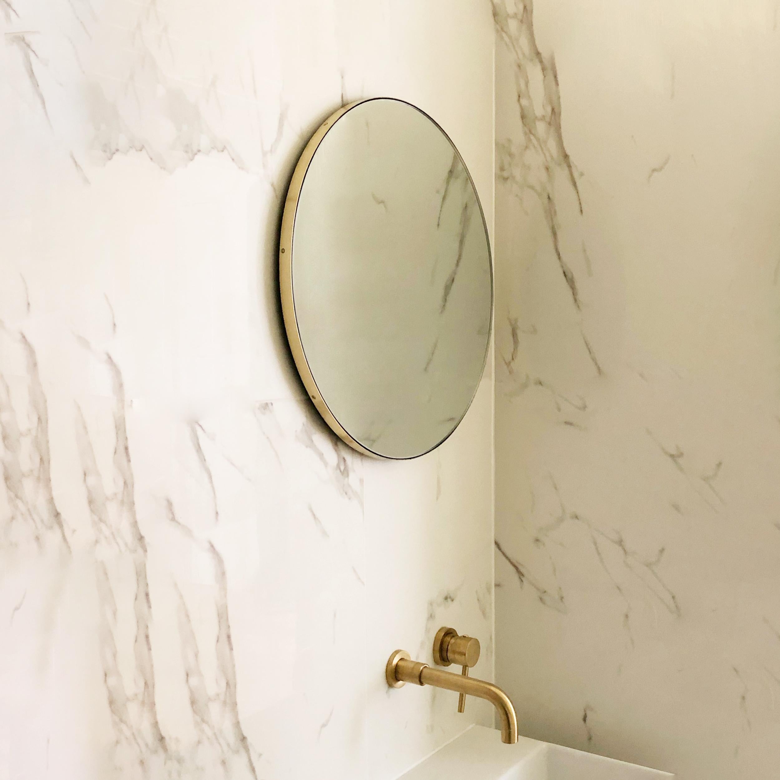 Minimalist Orbis™ round mirror with an elegant solid brushed brass frame. The detailing and finish, including visible brass screws, emphasise the crafty and quality feel of the mirror, a true signature of our brand. Designed and made in London,