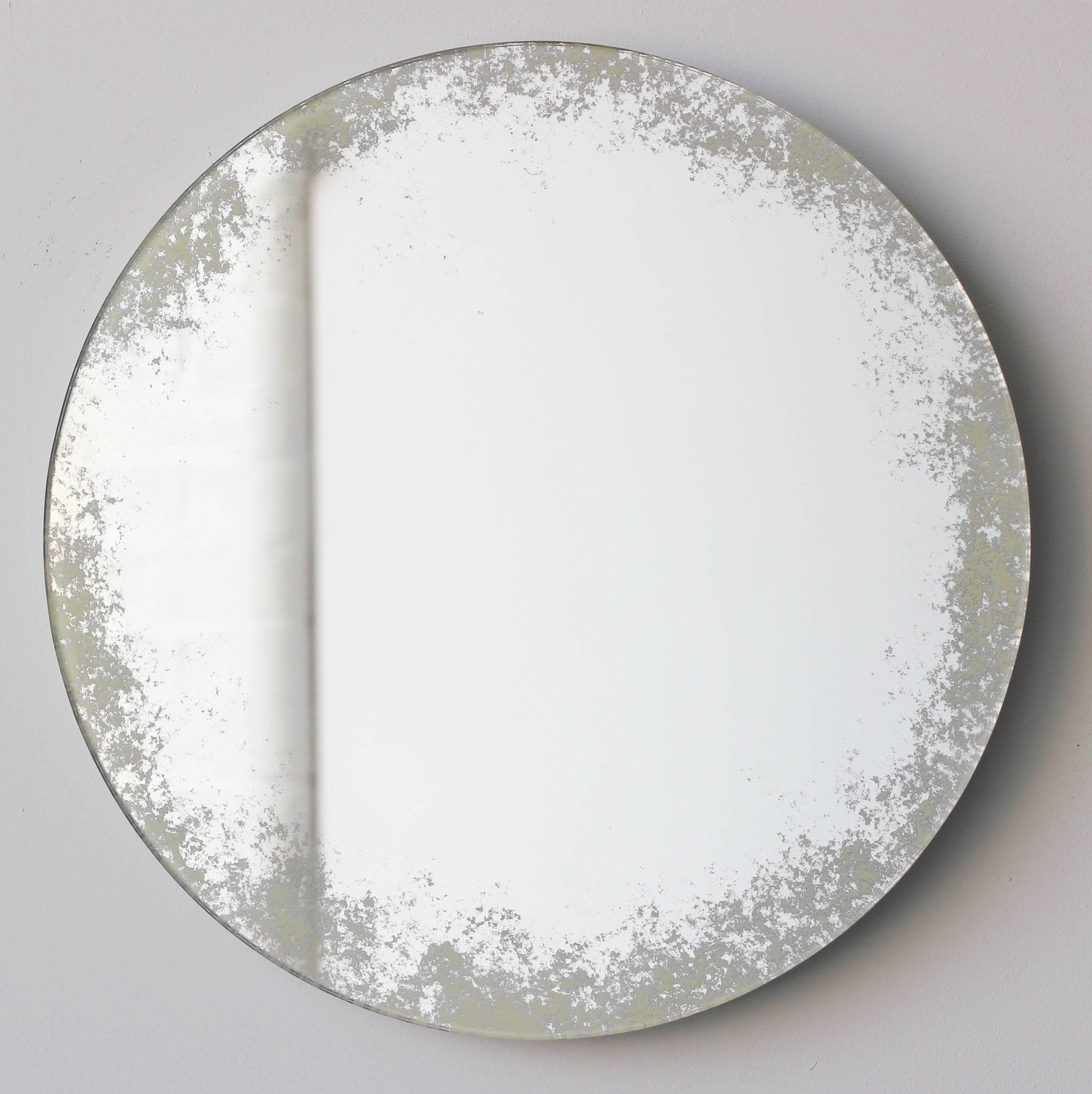 Delightful handcrafted silver mirror with an ivory antiqued finish around the edges.

The hand polishing of the edges and hand finish of the antiqued effect give it a very charming and classic crafted look, while still looking beautiful in a modern