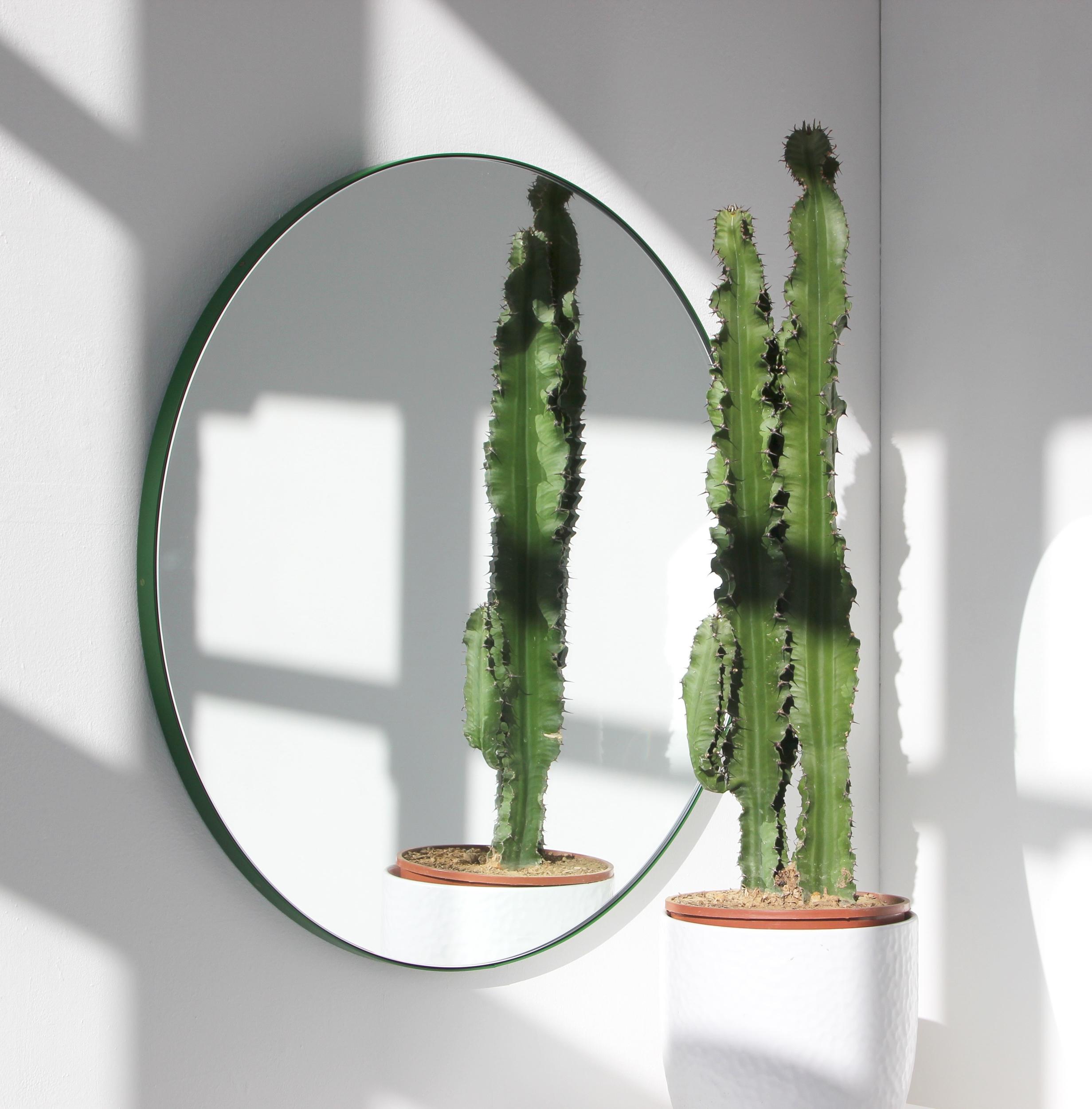Minimalistischer runder Spiegel mit einem lebendigen, grün pulverbeschichteten Aluminiumrahmen. Entworfen und handgefertigt in London, UK.

Unsere Spiegel sind mit einem integrierten französischen Befestigungssystem (geteilte Leisten) ausgestattet,