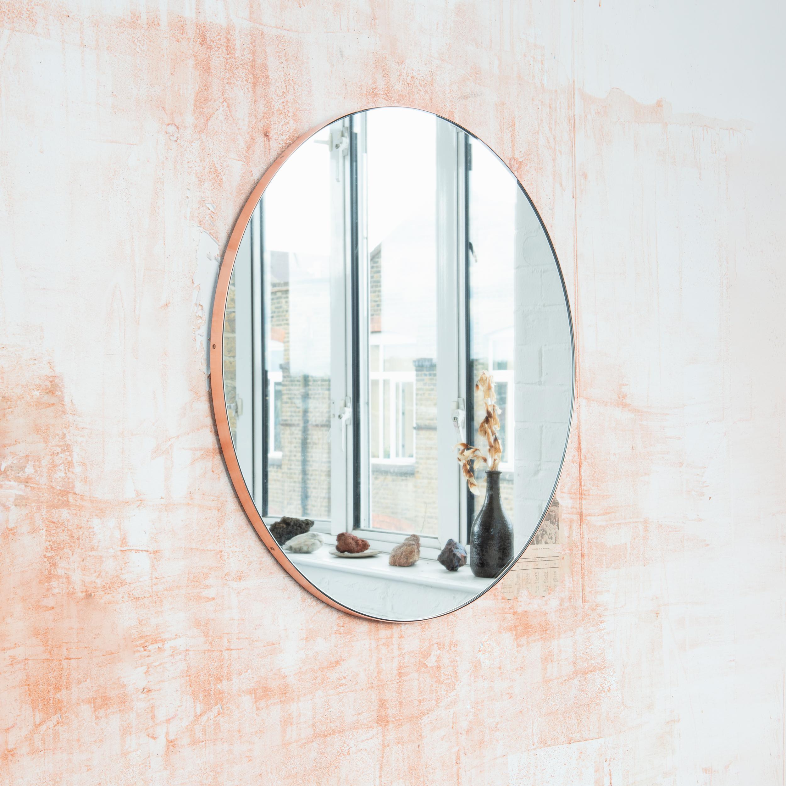 Miroir rond minimaliste avec un élégant cadre en cuivre brossé. Les détails et la finition, y compris les vis cuivrées visibles, soulignent l'aspect artisanal et la qualité du miroir, véritable signature de notre marque. Conçu et fabriqué à la main